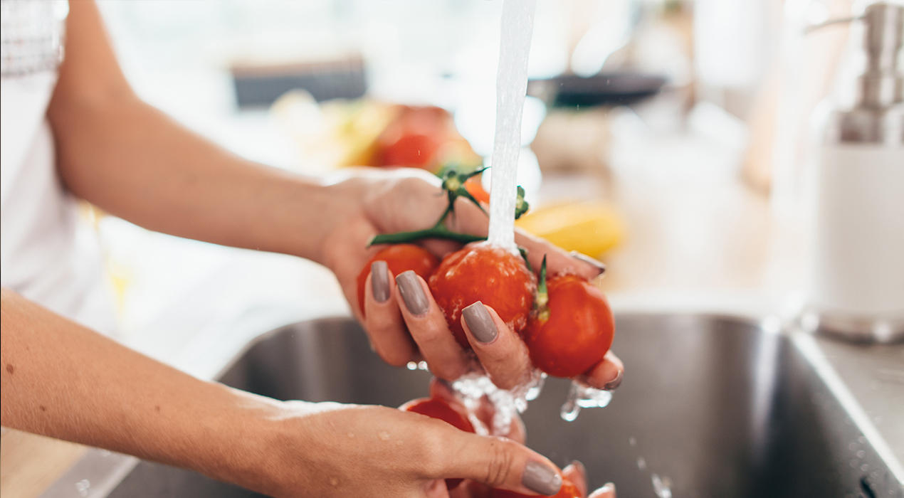 Tomaten waschen in einem Waschbecken aus Edelstahl
