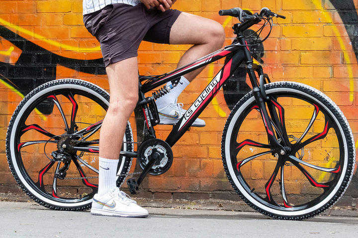 Ein Mann lehnt entspannt an seinem Fahrrad mit Ventilen.