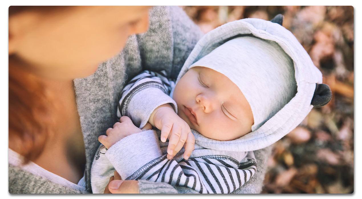 Frau mit schlafendem baby auf dem Arm 