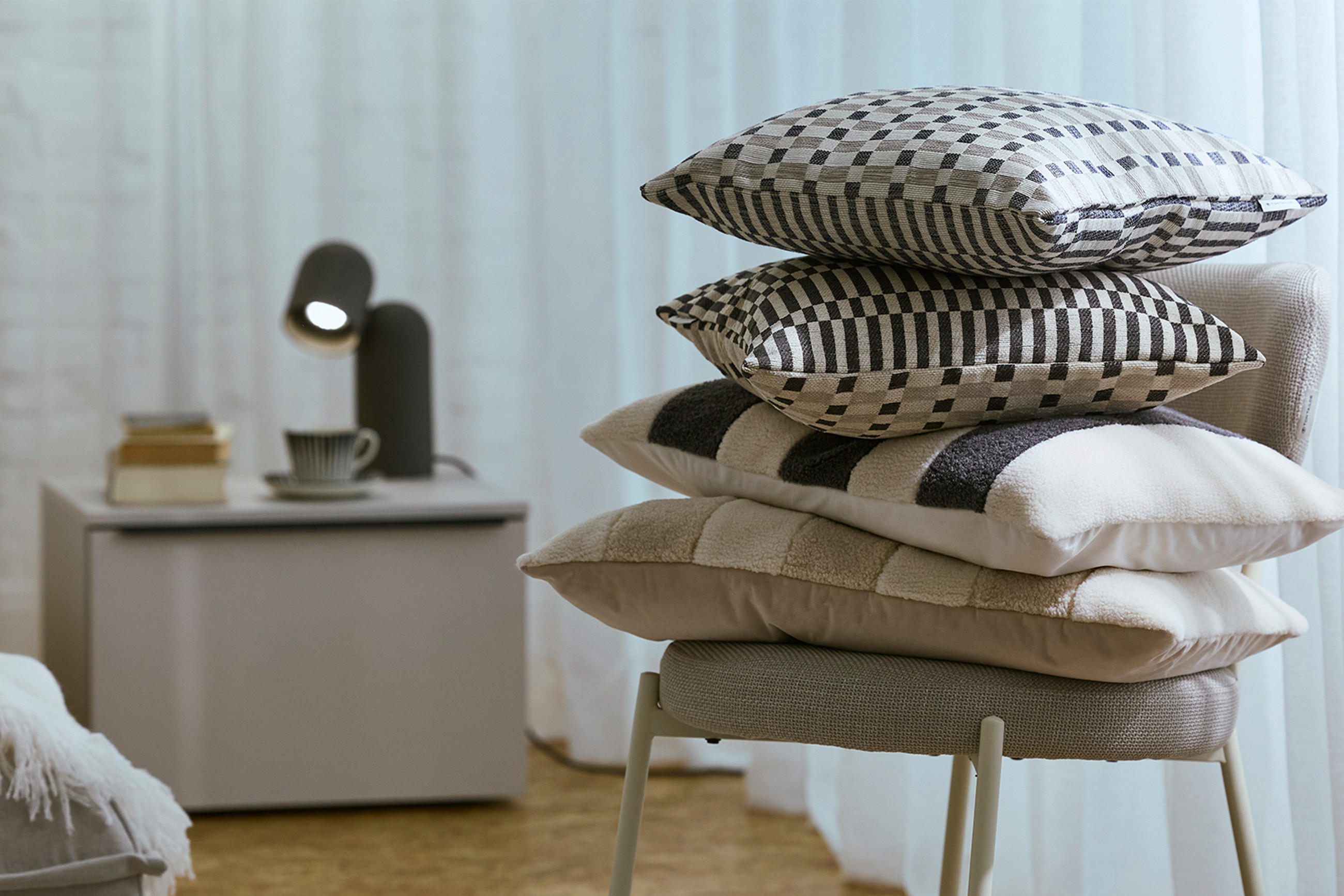 Schlafzimmer mit einem Stuhl und verschiedenen Kissen