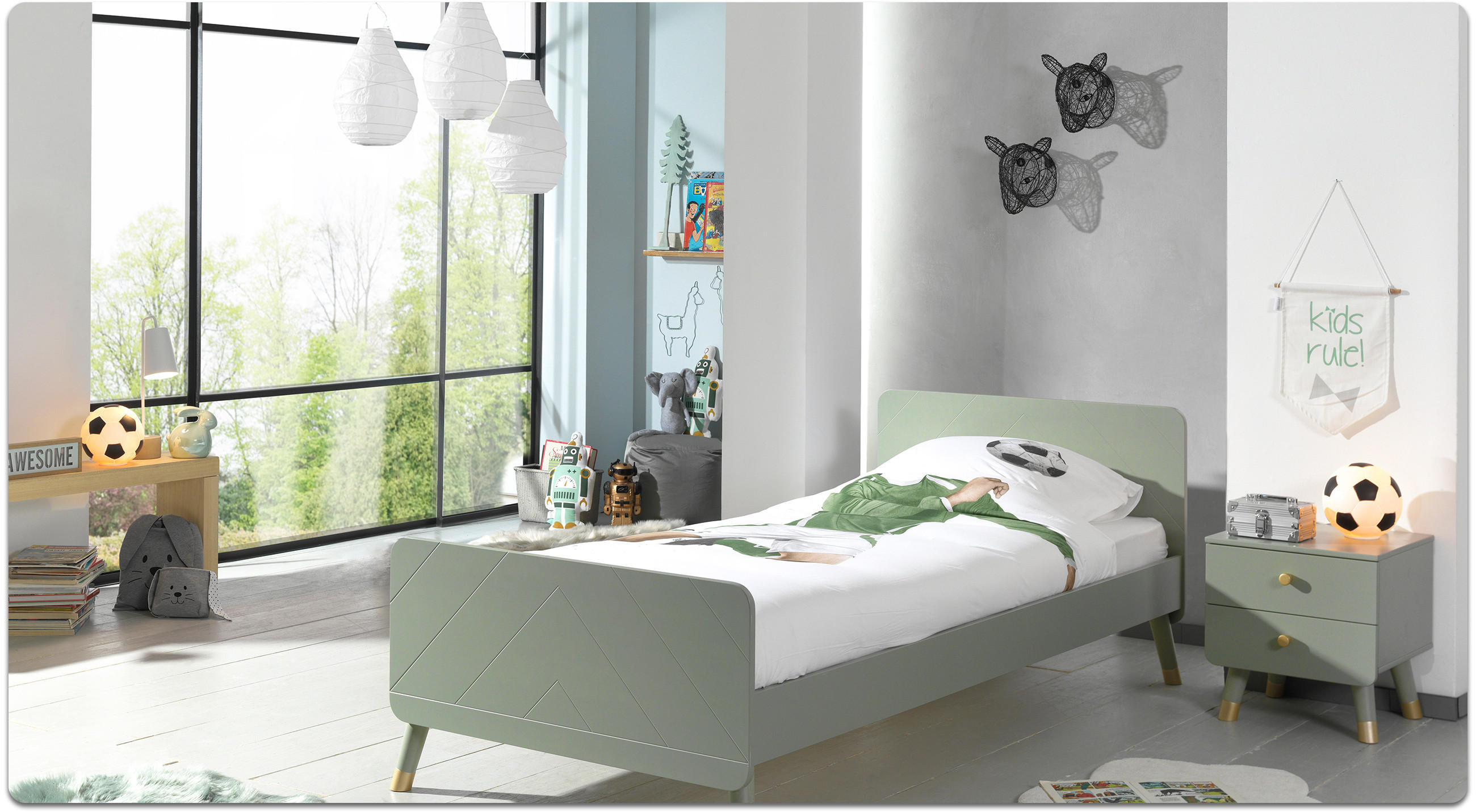  Kinderzimmer mit grünem Bett, Nachttisch, Fußball-Dekoration und großen Fenstern.