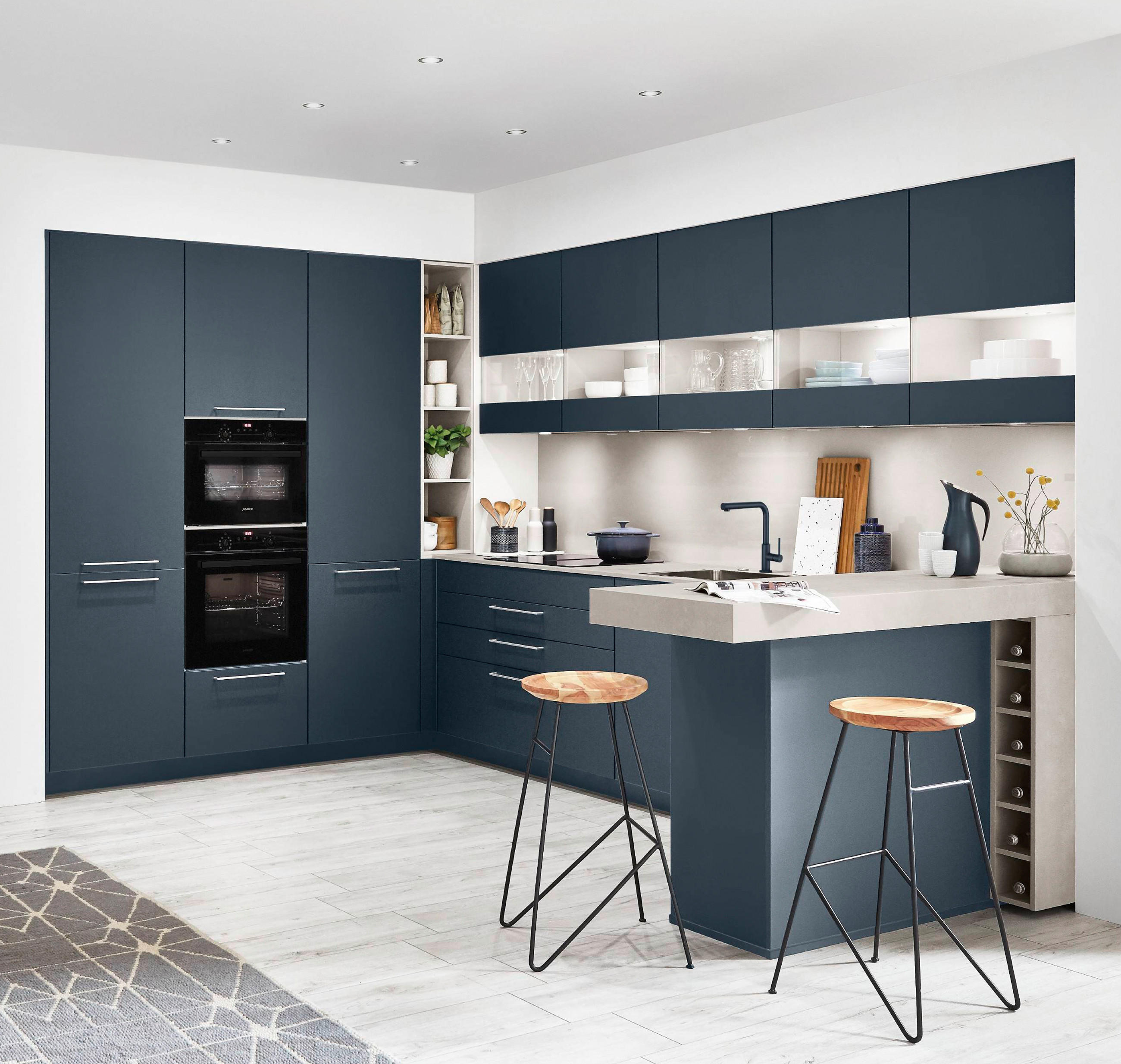Moderne Küche mit blauen Schränken und heller Arbeitsplatte
