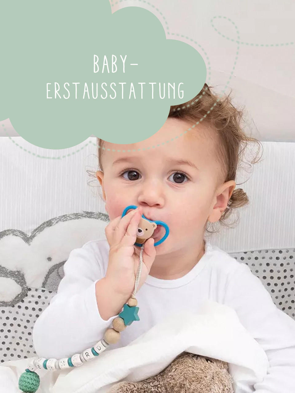 Baby mit Schnuller auf dem bett