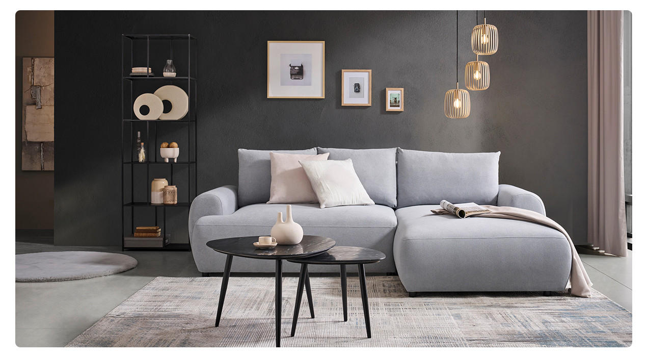schwarze Wand davor graue Couch und schwarze Tische