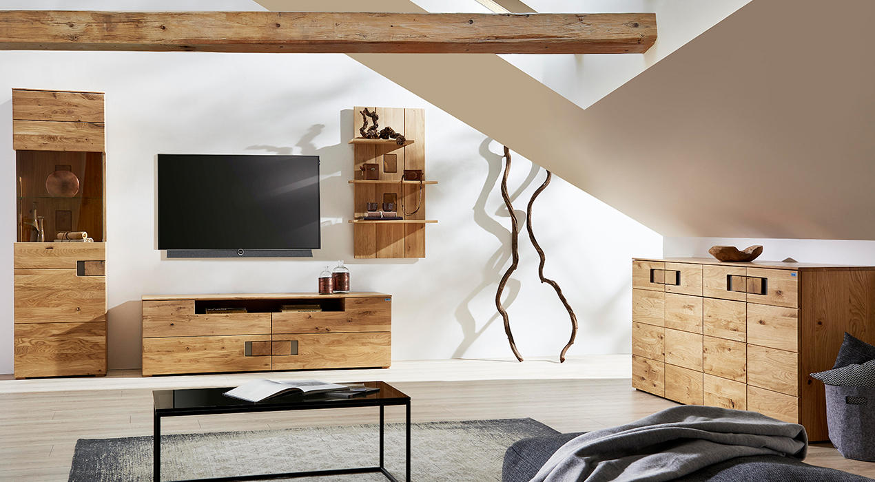 Komplette Wohnwand mit Lowboard, Highboard, Vitrine und Hängeelement aus hellem Eichenholz.