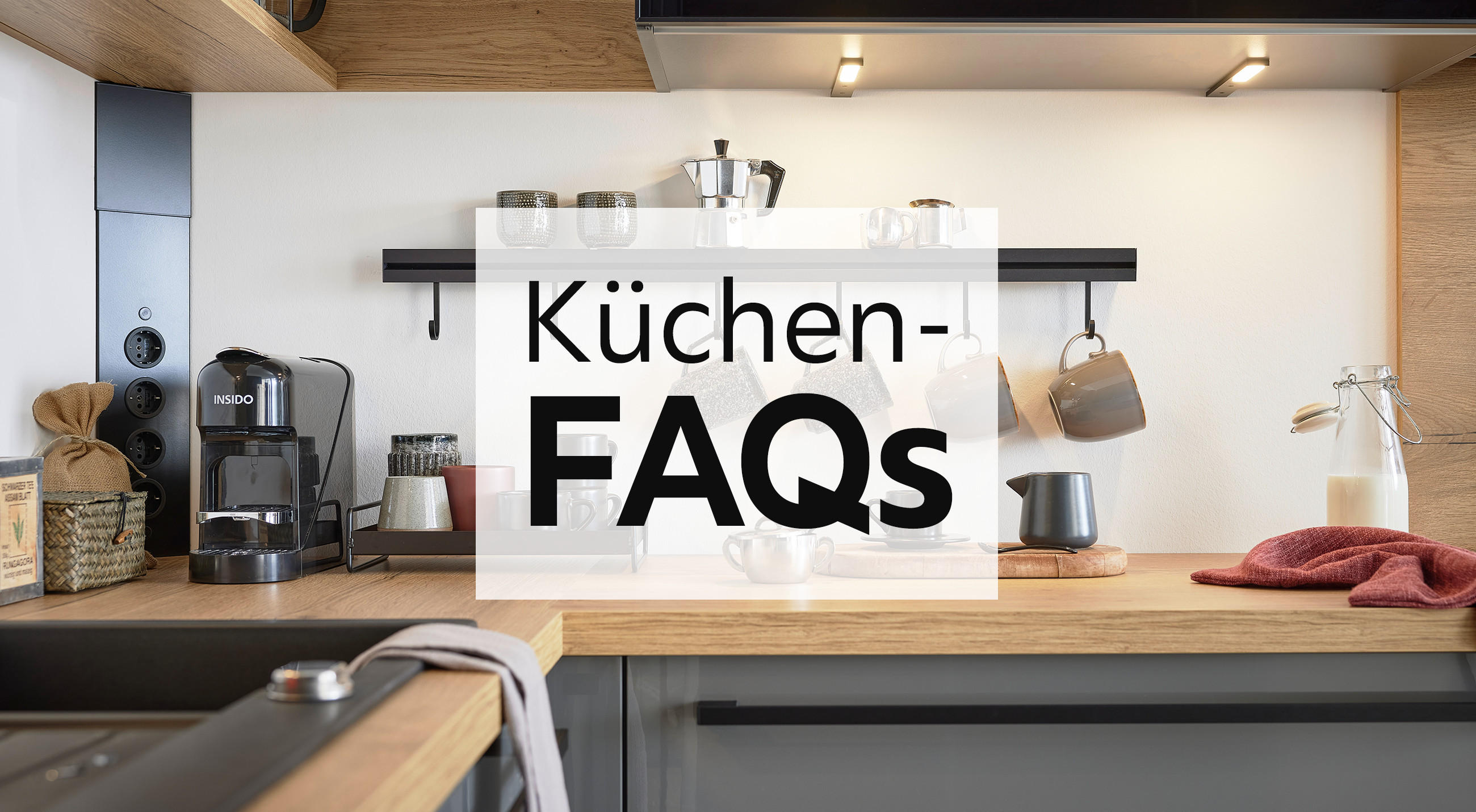Küchen FAQs, Infos rund um das Thema Küche bei XXXLutz, Küche mit grauen Fronten und Arbeitsplatte aus Holz, Küchenhelfer und Küchenelektrogeräte