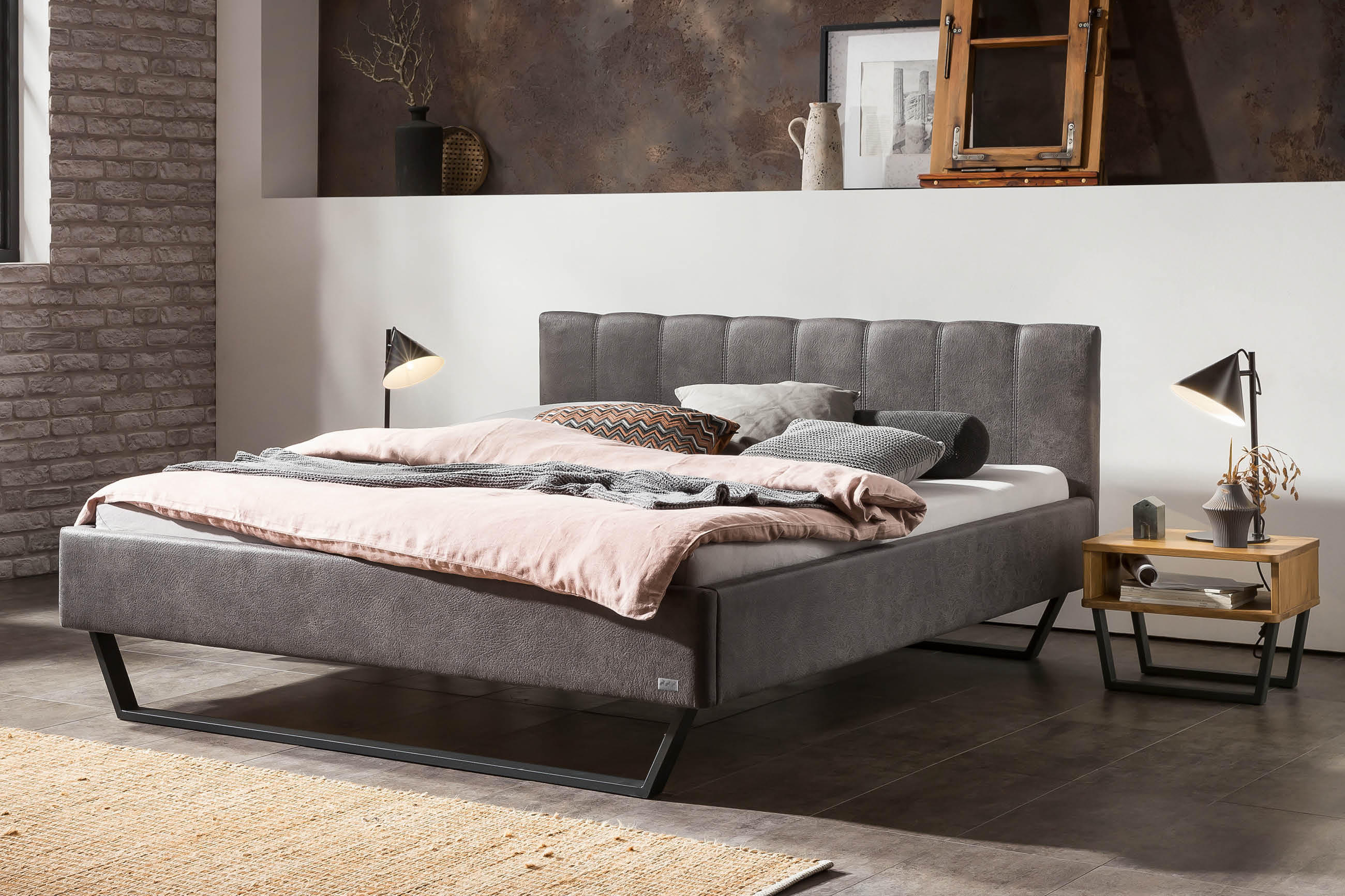 Hasena Komfortbett mit weich gepolstertem Kopfteil und Bettrahmen aus geprägten Mikrofasern „Tocco“ und „Buffalo“, inszeniert mit gemütlicher Bettwäsche und warmem Licht in einem modernen Schlafzimmer.