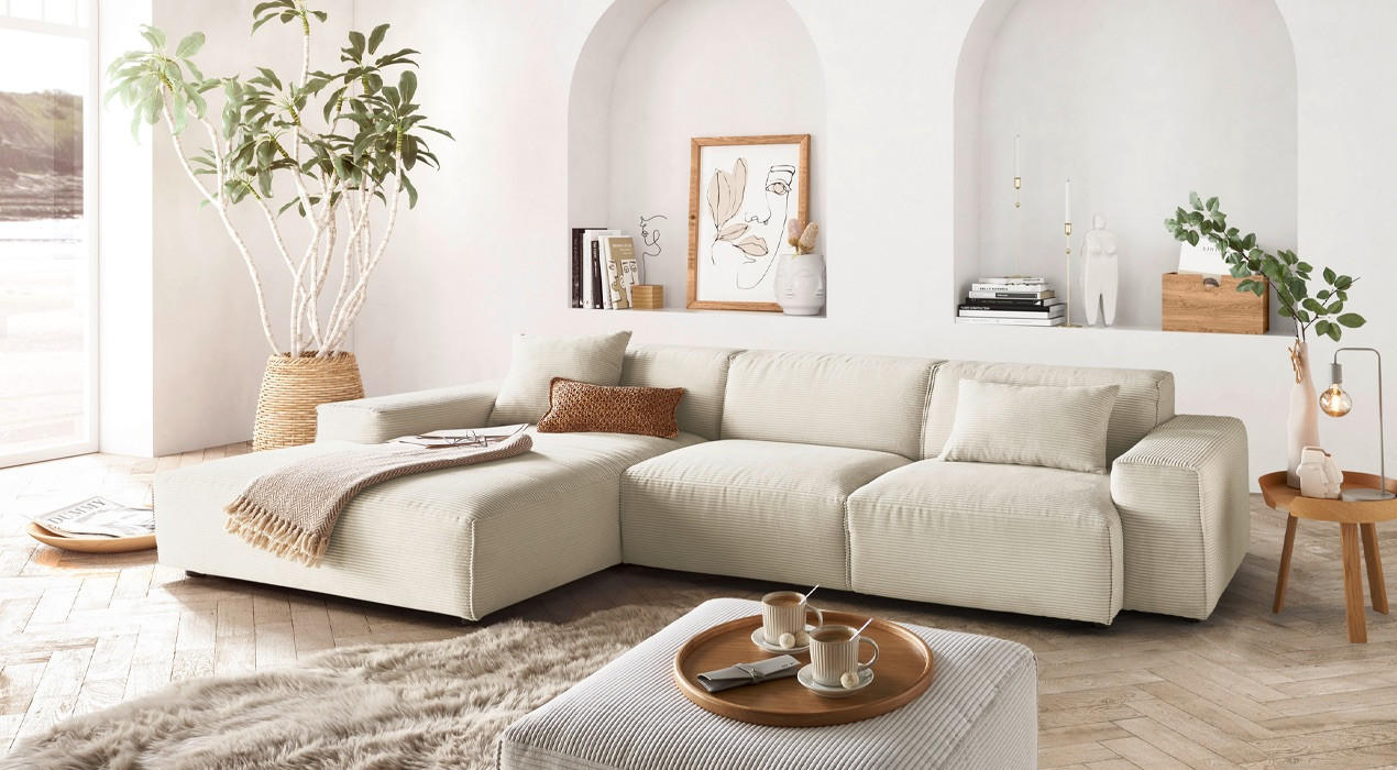 beige couch mit hocker und teppich