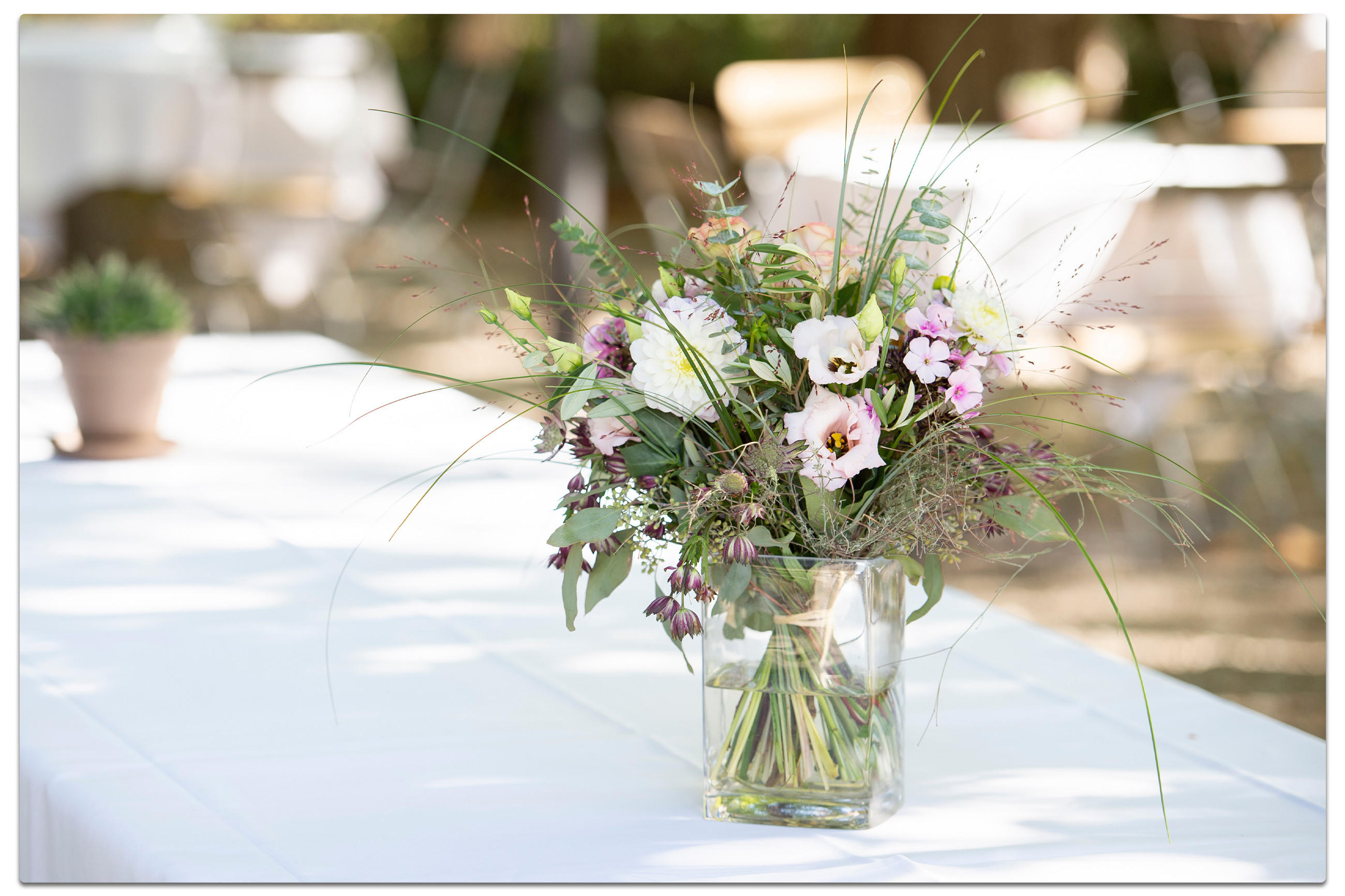Eine Vase mit bunten Blumen steht auf einem Tisch, passend zum Oktoberfest-Thema für eine festliche Atmosphäre.