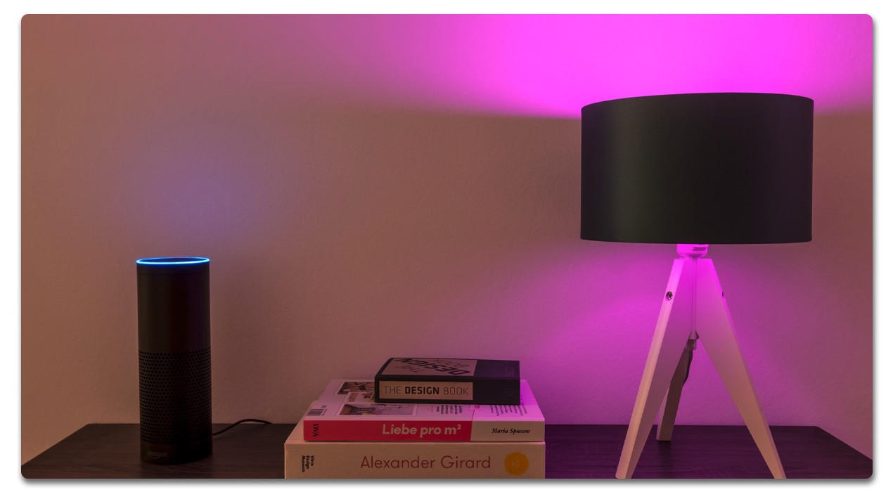 Nachttischlampe mit rosa licht auf einem Schränkchen