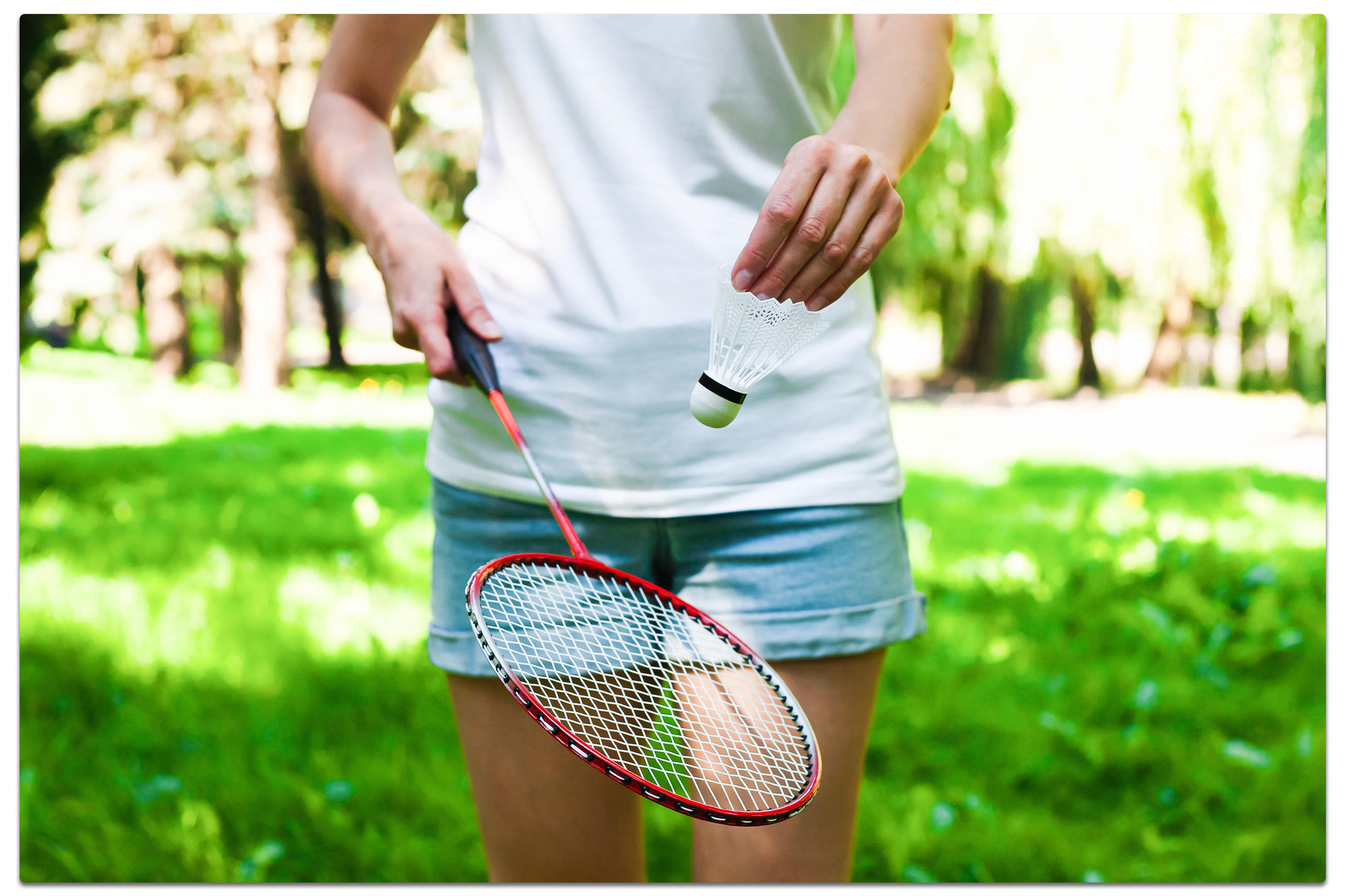 Eine Frau hält einen Badmintonschläger und einen Ball