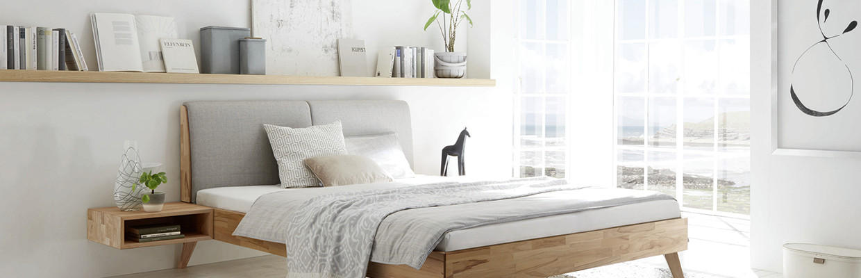 Schlafzimmer mit Holzbett in hellen Tönen