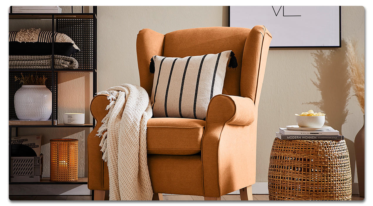 Gemütliches Wohnzimmer, Sessel, Decke, Kissen, Hocker, Regal, Bild