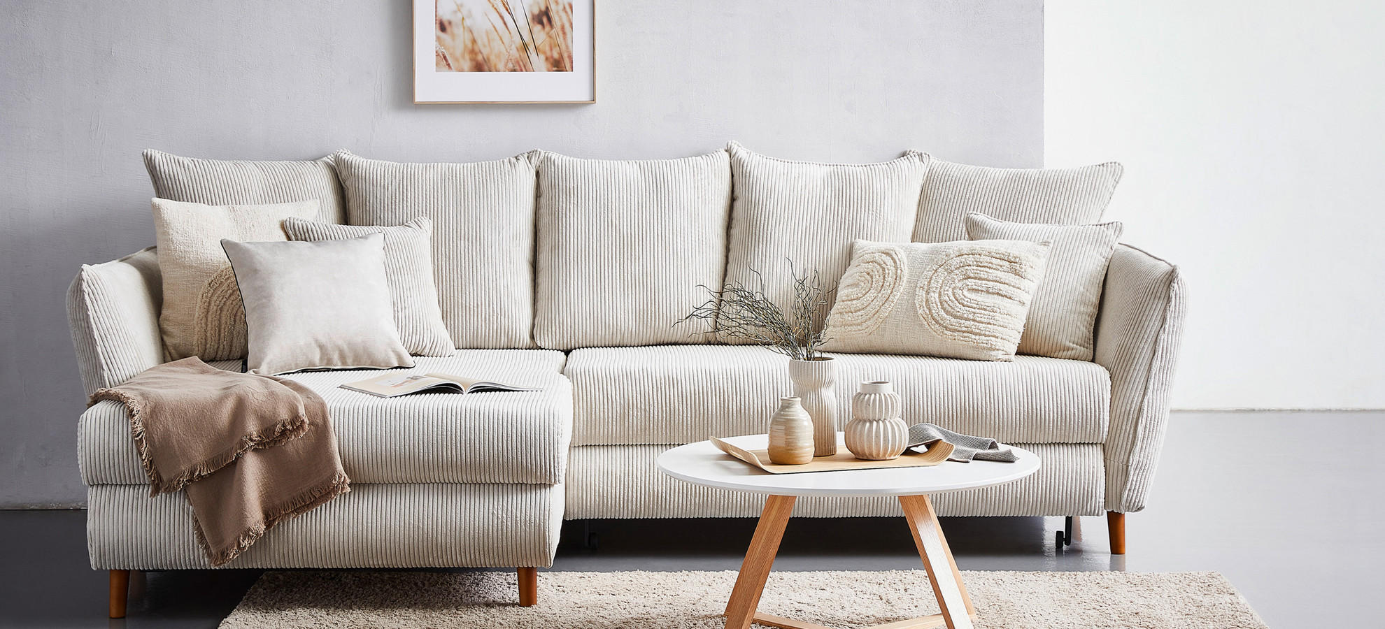 beige couch mit brauner decke und beigem teppich