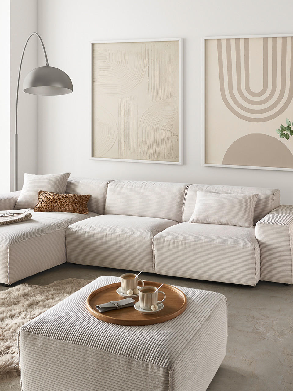 Wohnzimmer mit weißem Sofa und Bildern in Beigetönen