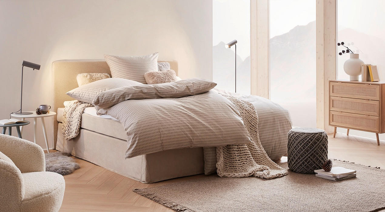 boxspringbett in beige mit decke und kissen