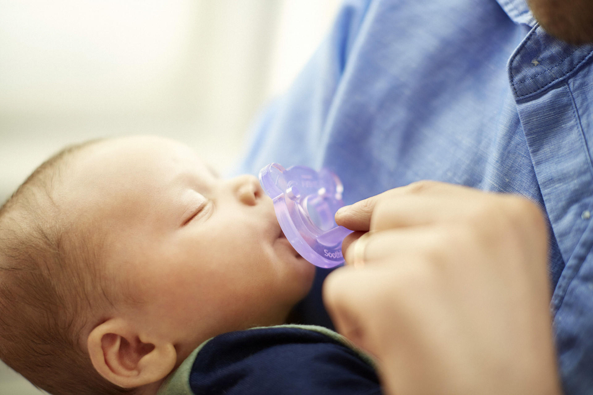 Baby mit lilafarbenen Schnuller