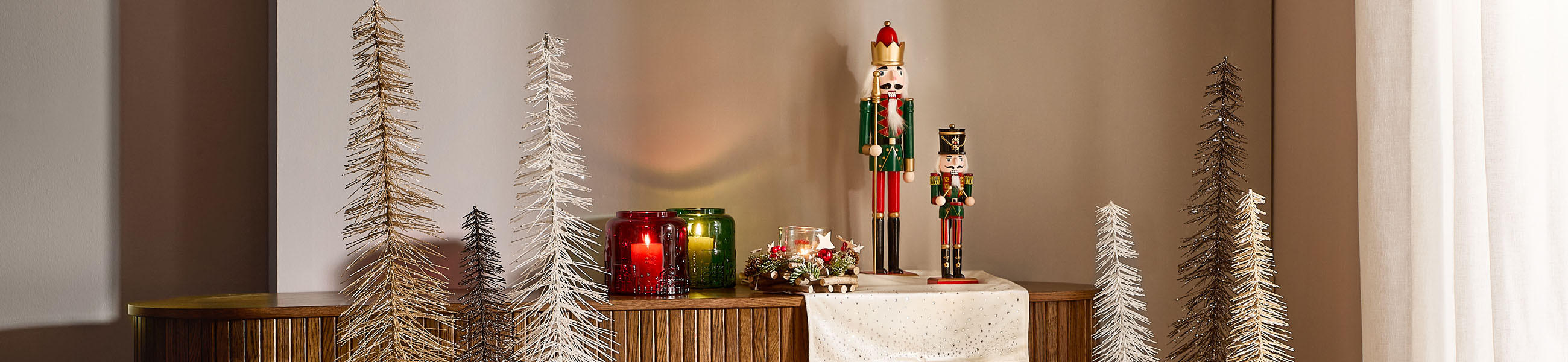 Zwei Nussknacker mit Weihnachtsdeko auf Holzfläche.