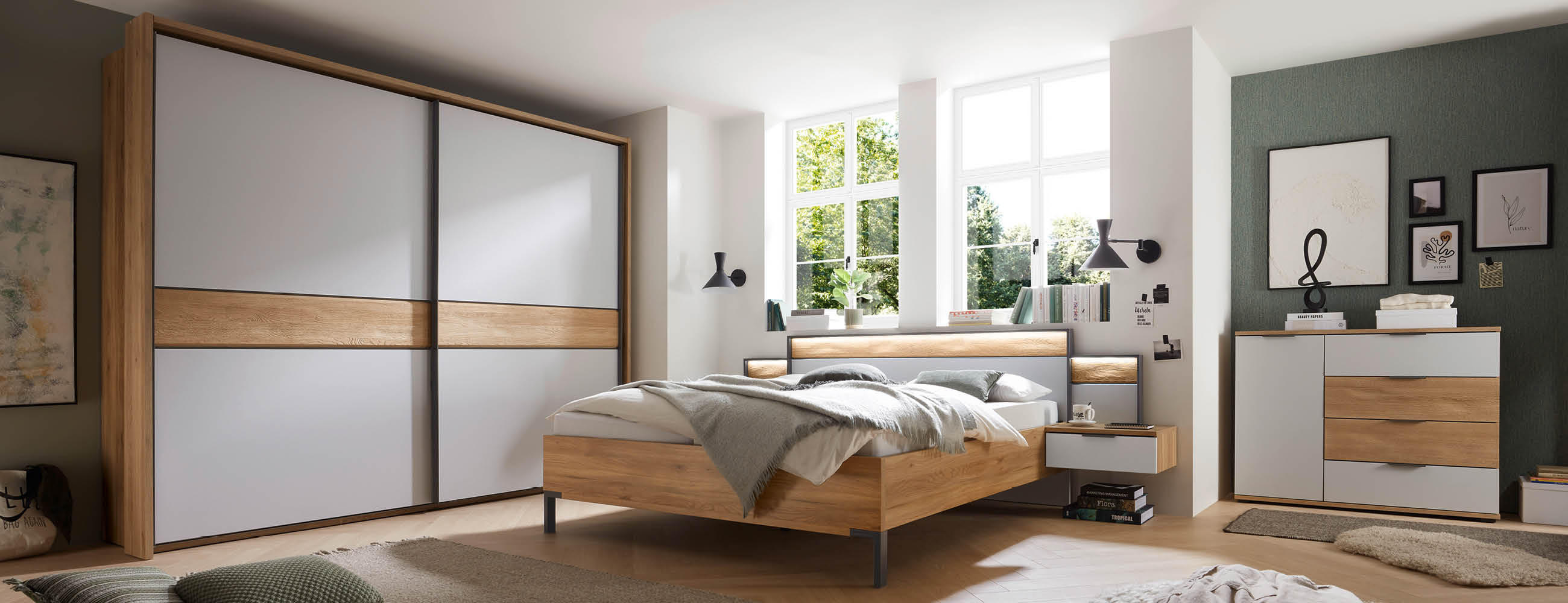 Ein gemütliches Schlafzimmer mit einem Bett, einer Kommode und einem Kleiderschrank aus Holz in der Farbe weiß.