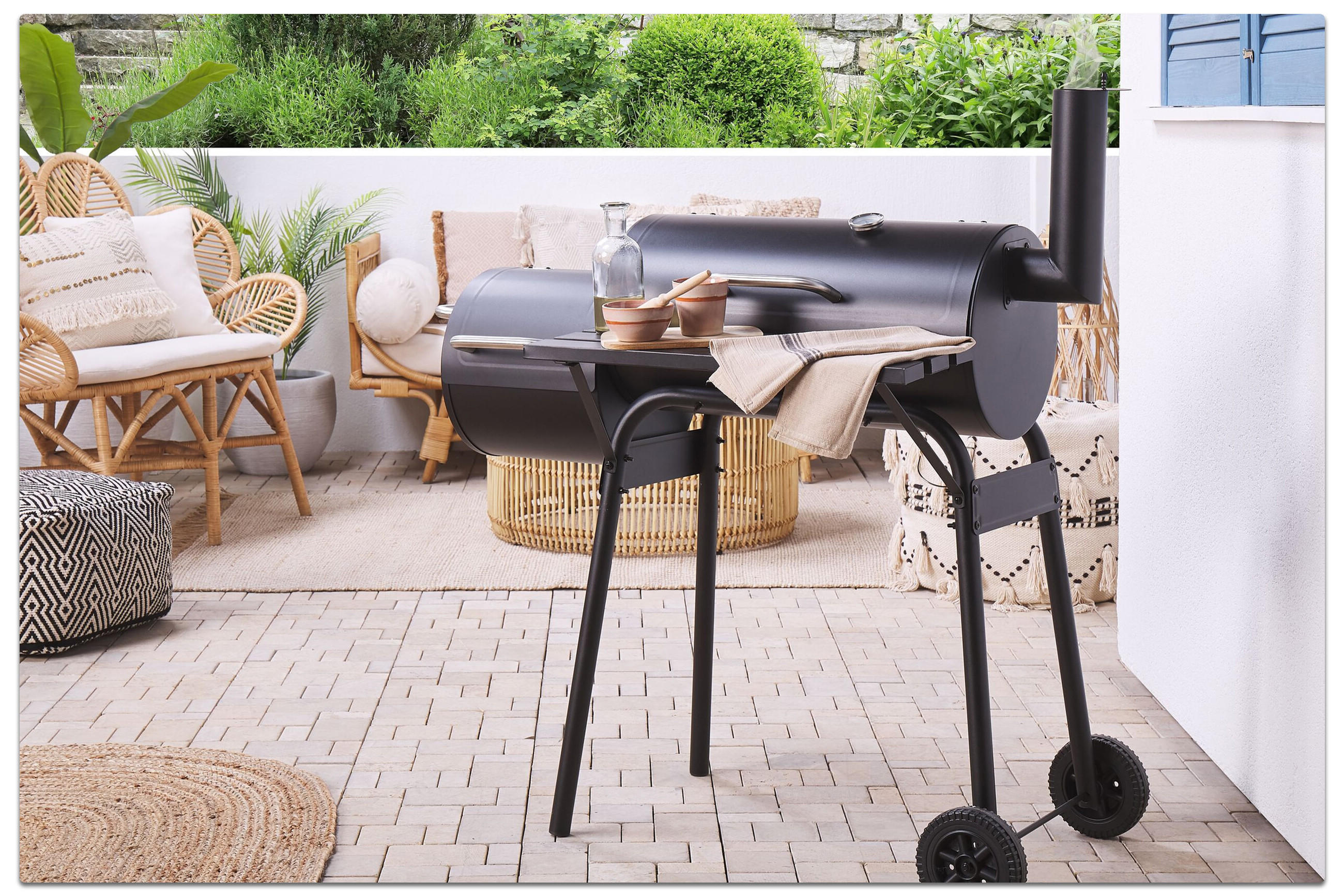 Grill auf Terrasse mit Tisch und Stühlen für Grillabende im Freien