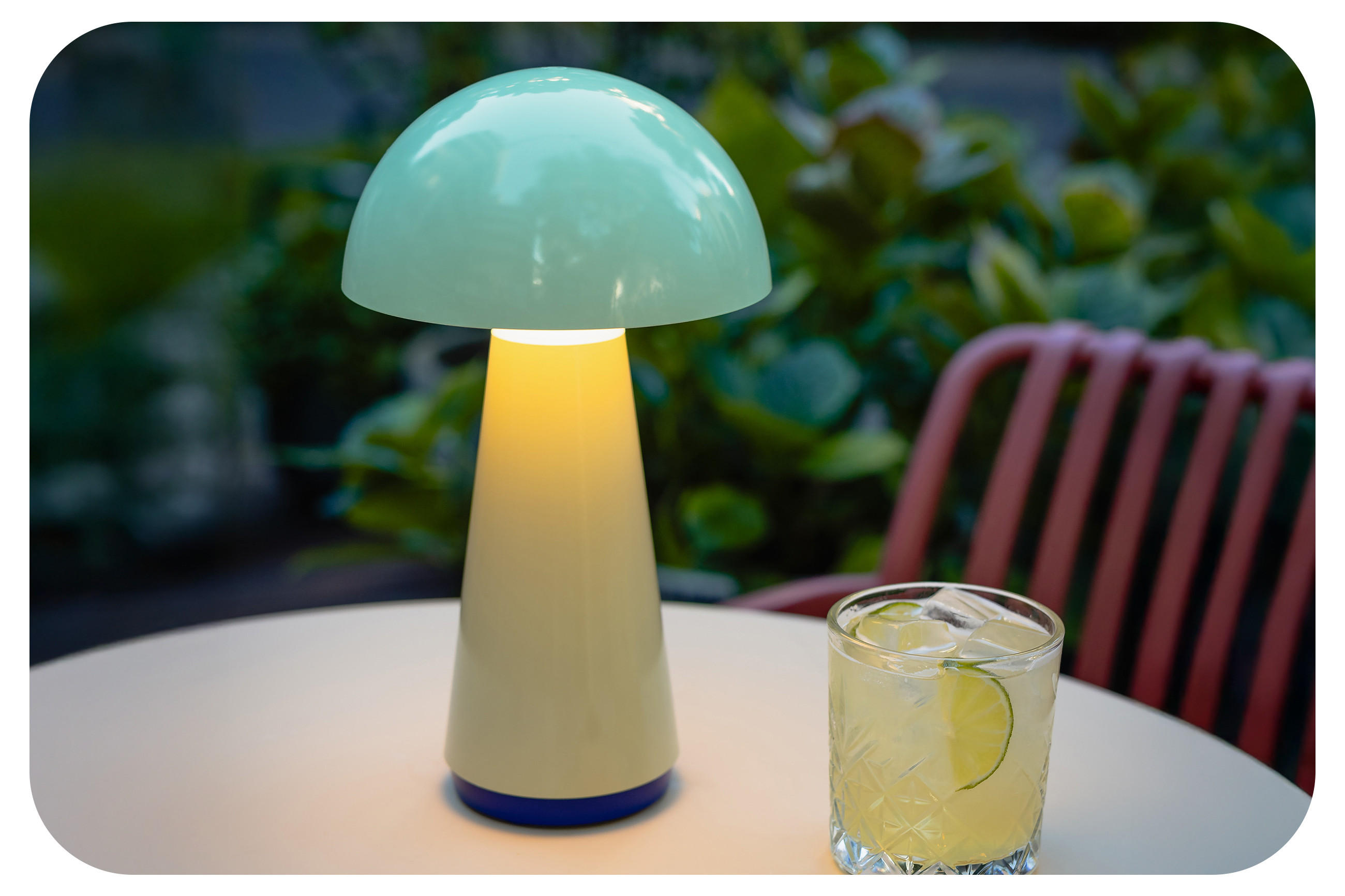 Tisch mit Mushroom-Tischleuchte und Cocktailglas. 