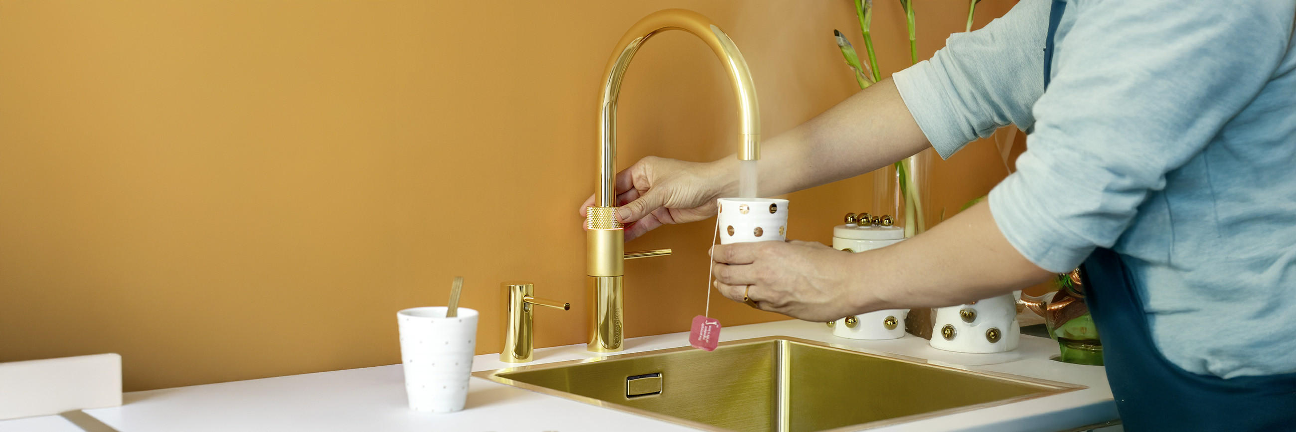 Frau füllt ihre Tasse mit heißem Wasser