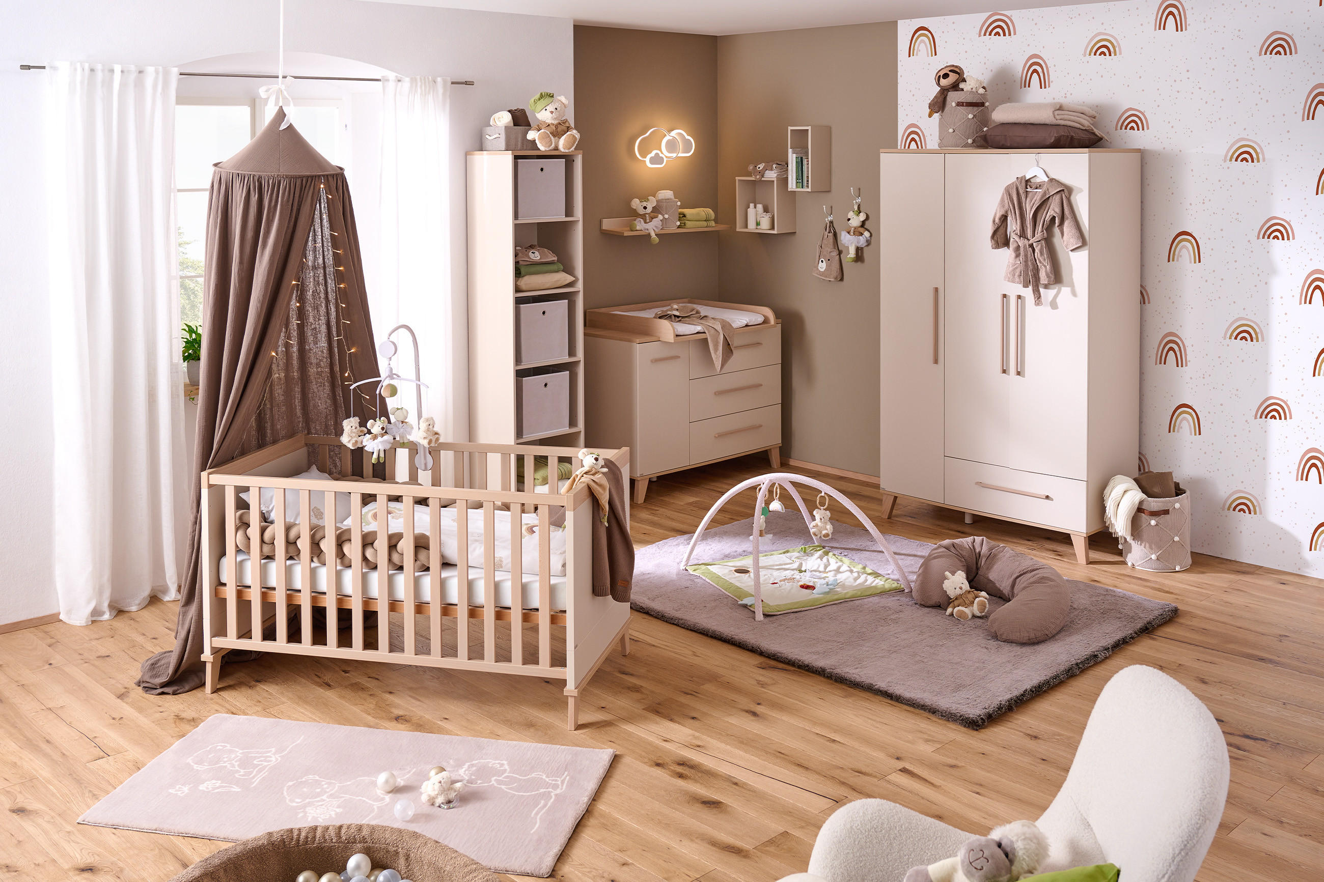 Liebevoll eingerichtetes Babyzimmer in neutralen Farben mit Gitterbett, Wickelkommode und Spielmatte. Dekoriert mit Stofftieren und dezenten Mustern