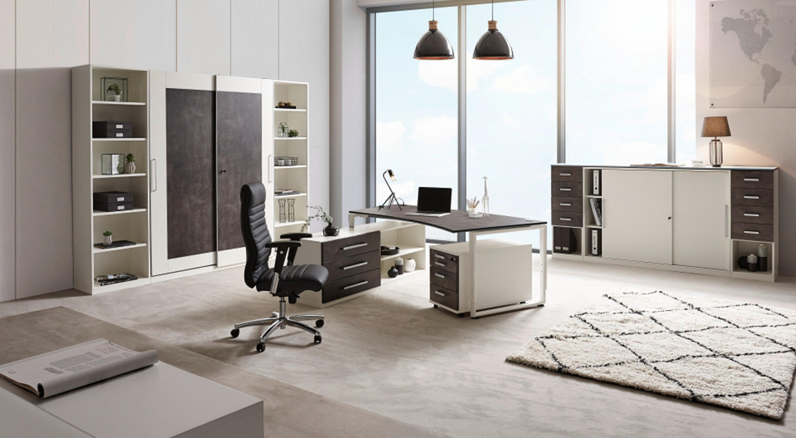 Modernes Büro mit großem Schreibtisch, schwarzem Bürostuhl, Regalen, Schränken, Weltkarte an der Wand und großen Fenstern mit Tageslicht.