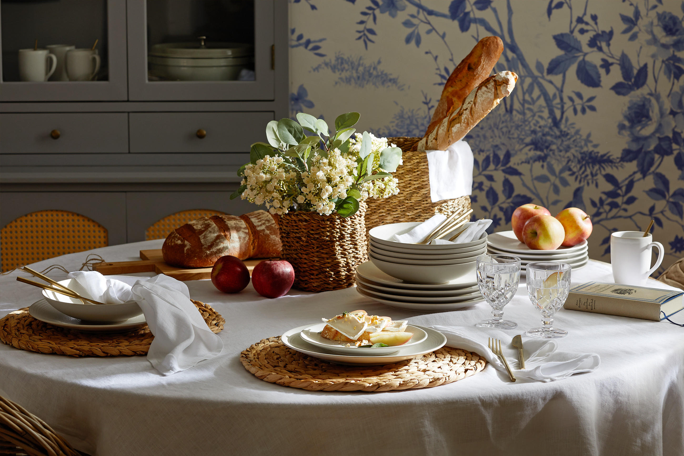 Festlich gedeckter runder Tisch mit weißer Tischdecke für einen Osterbrunch im Country-Cottage Style