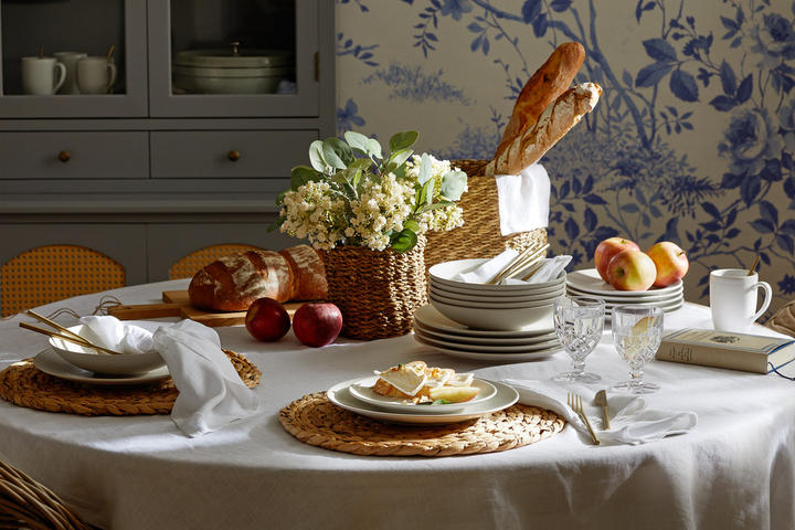 Festlich gedeckter runder Tisch mit weißer Tischdecke für einen Osterbrunch im Country-Cottage Style