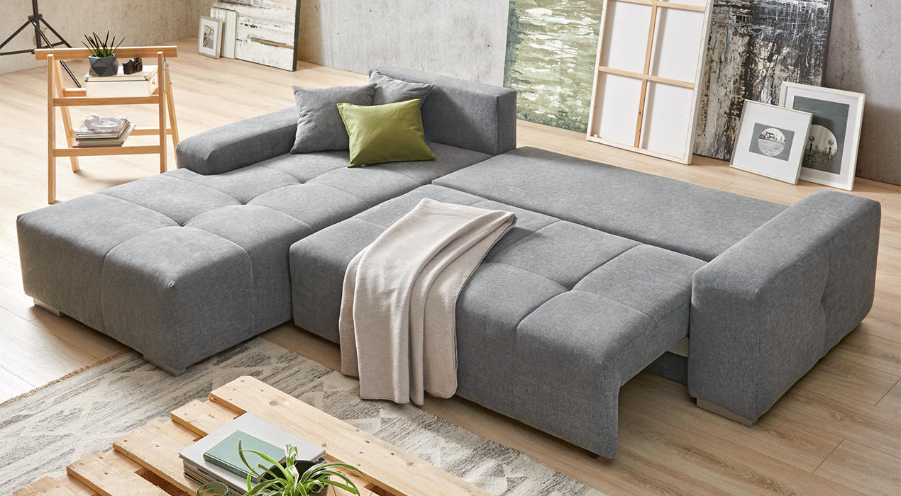 Wohnlandschaft mit ausgeklappter Schlaffunktion in Grau