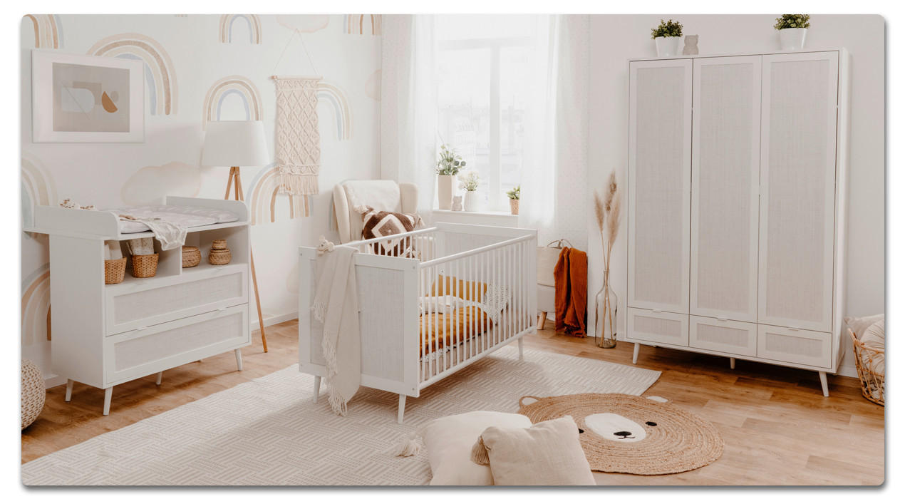 helles babyzimmer mit babygitterbett im vordergrund
