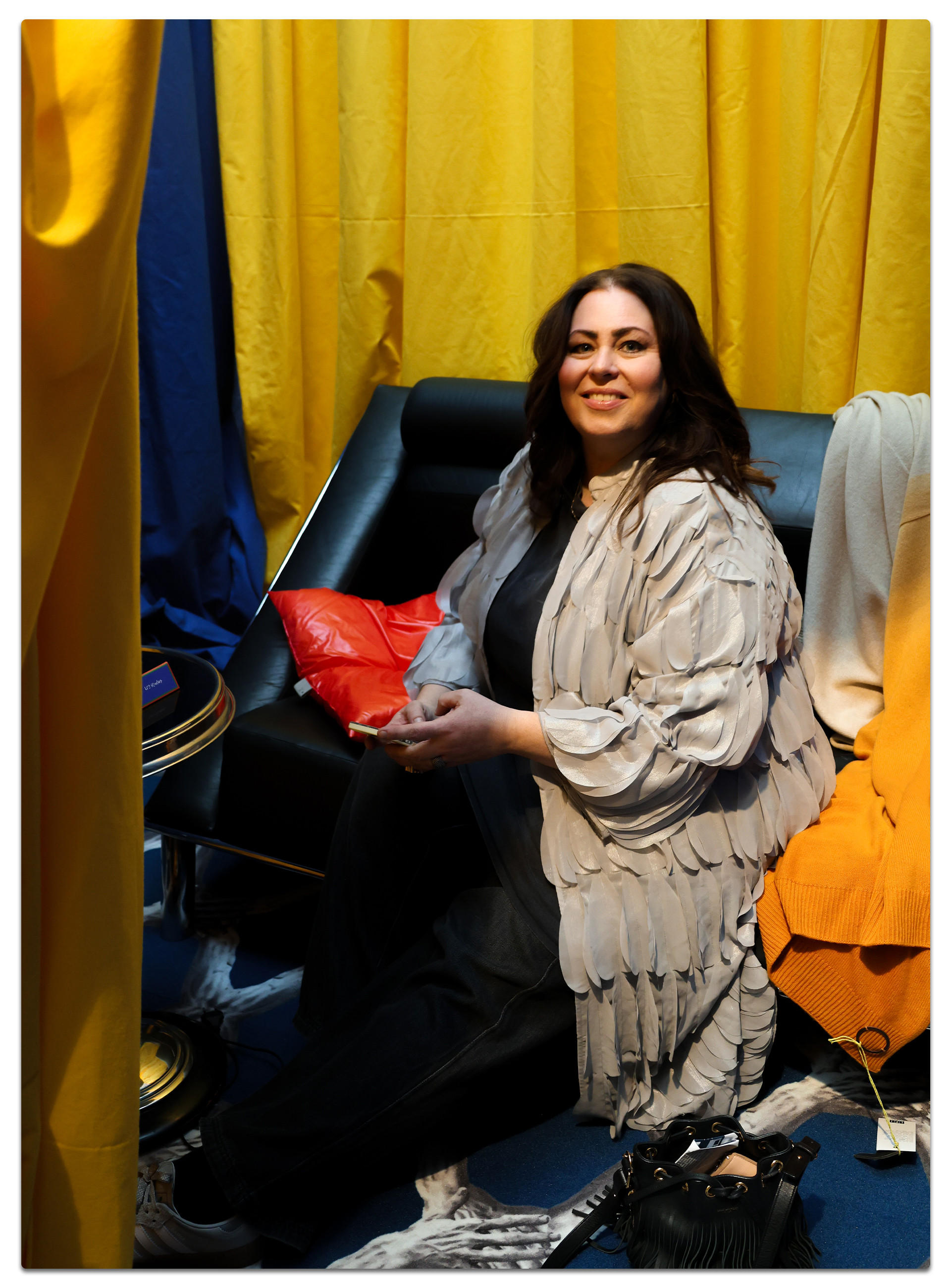 Daniela Witzel sitzt auf einem Sofa, umgeben von einem gelben Vorhang, Ambiente Messe 2025