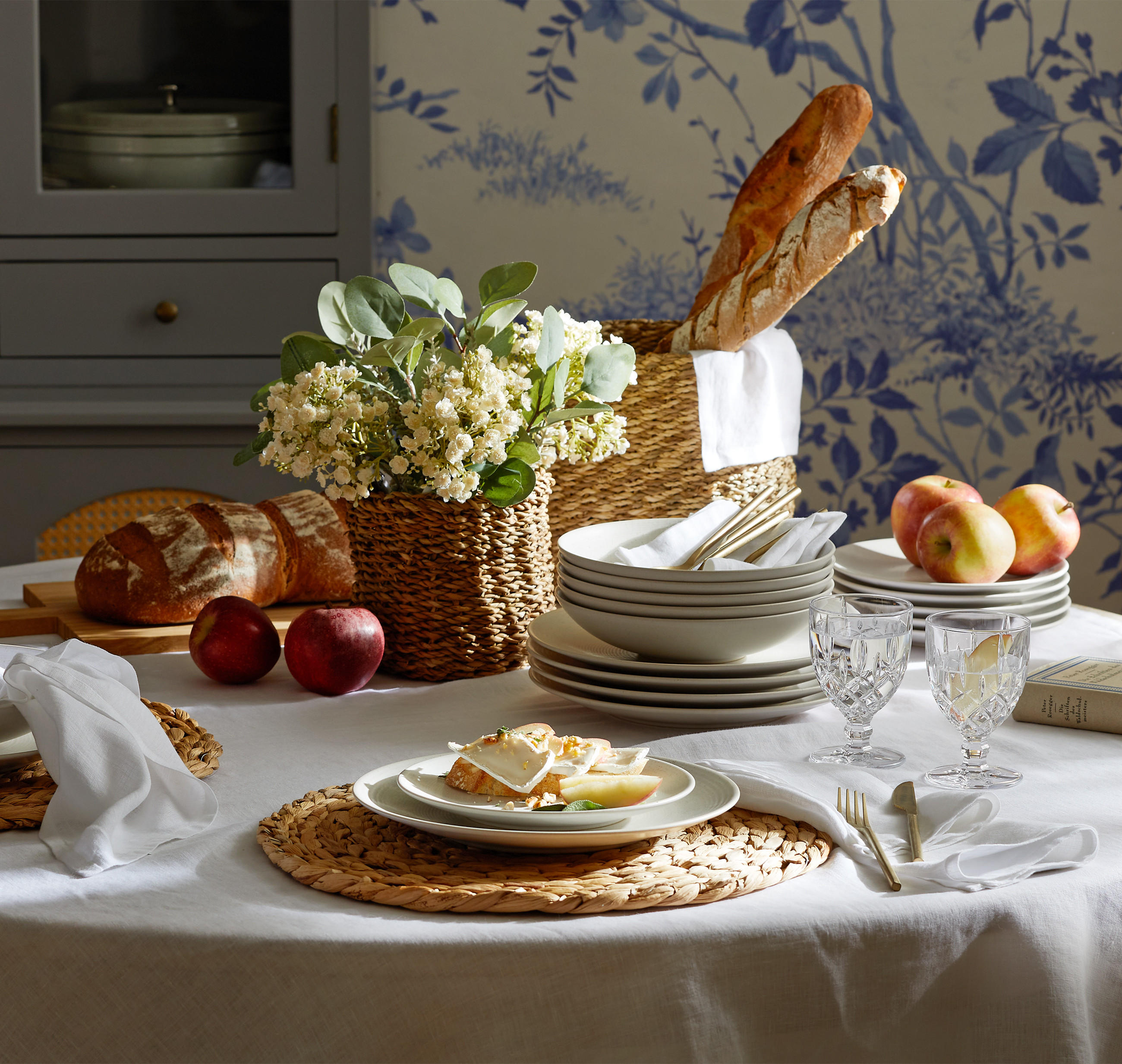 Festlich gedeckter runder Tisch mit weißer Tischdecke für einen Osterbrunch im Country-Cottage Style