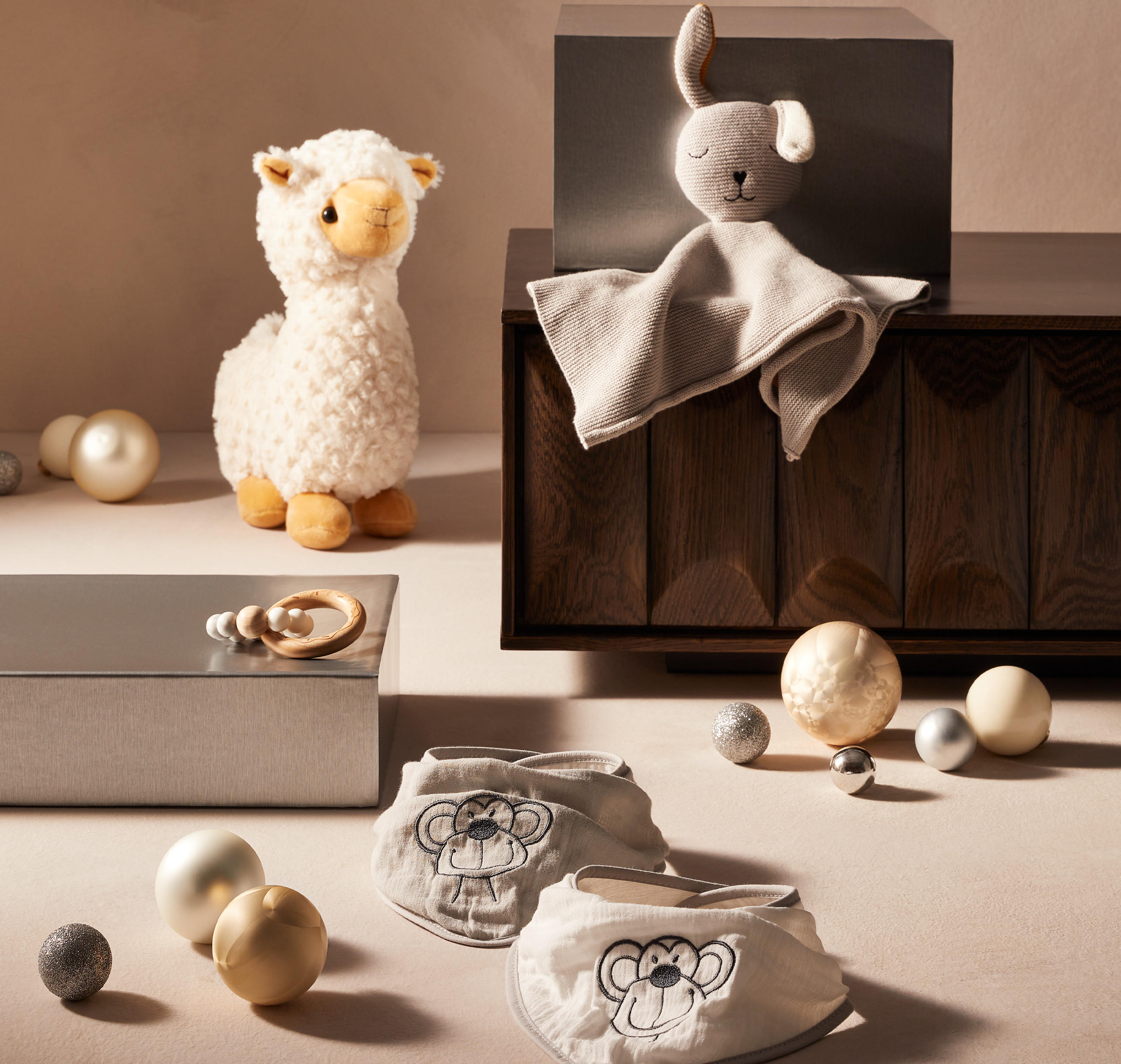 Kuscheltiere für Babys in weihnachtlicher Atmosphäre mit Christbaumkugeln