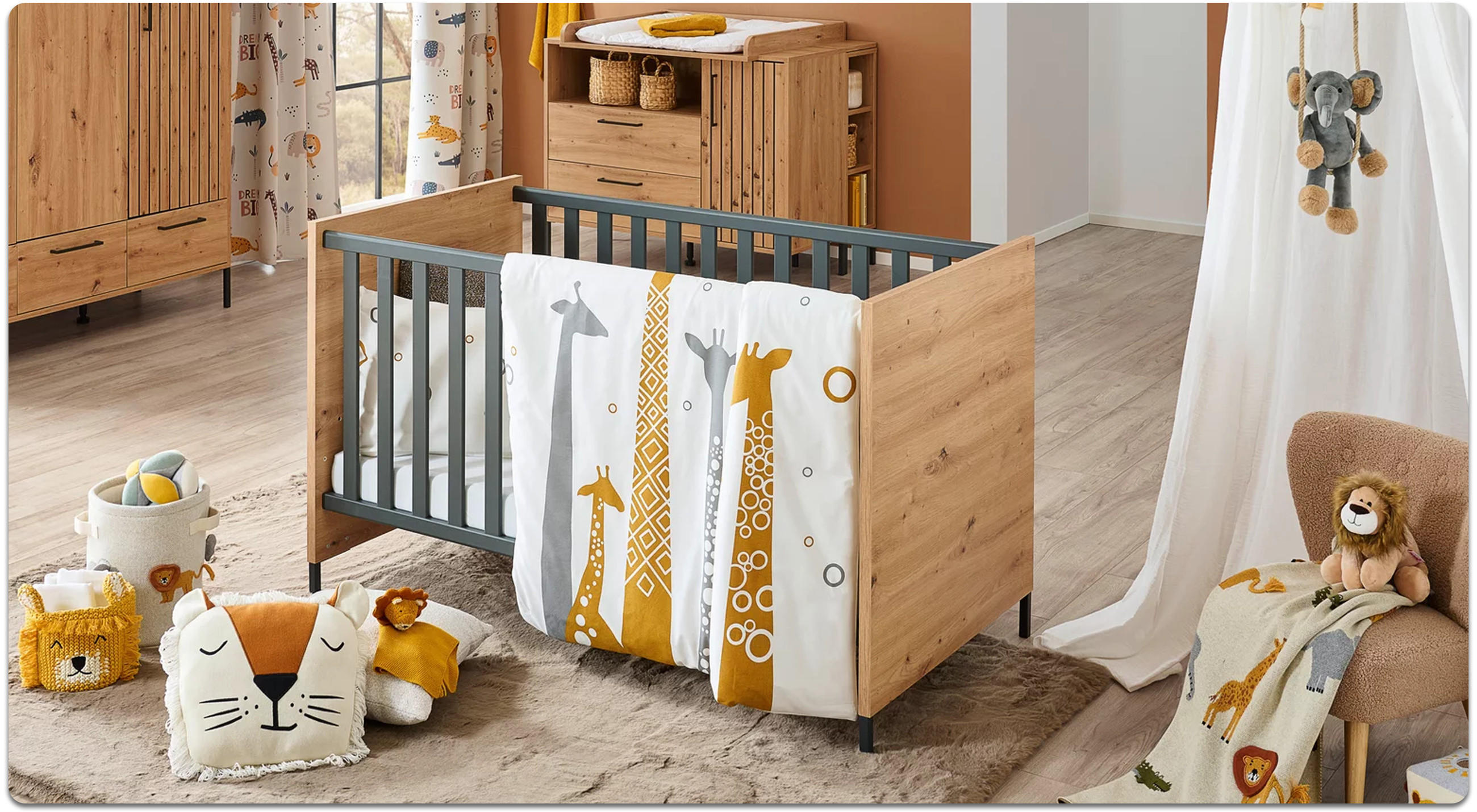 Kinderzimmer mit Holz-Kinderbett und gemusterter Bettwäsche mit Giraffen, daneben Tipi-Zelt und Spielzeug auf hellem Holzboden.