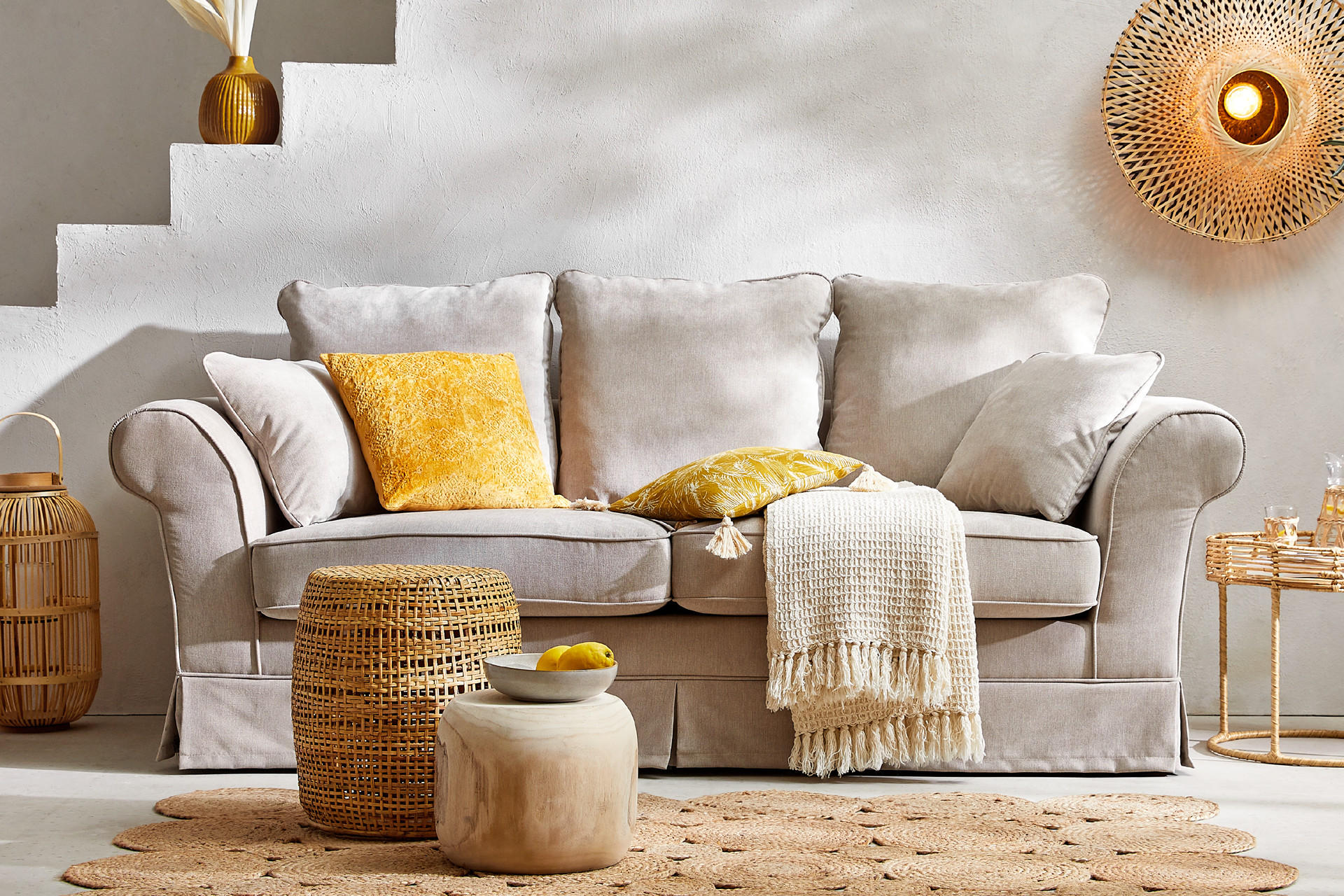 Grau Sofa mit sommerlichen Heimtextilen und Dekor