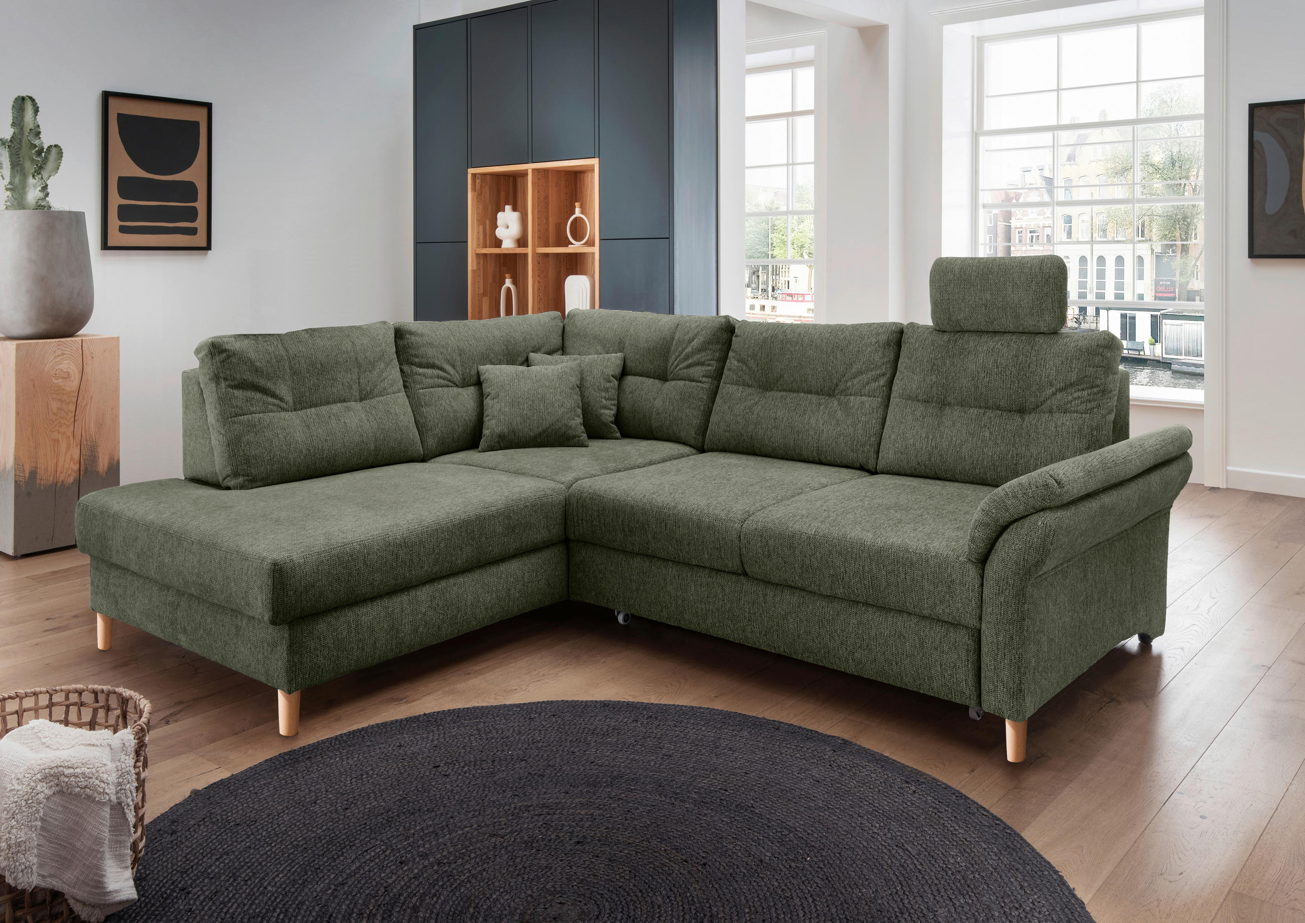 Livetastic ECKSOFA Dunkelgrün Chenille, links davon: Hochflorteppich, Hocker in weiß, Beistelltisch, rechts davon: Kissen in grün in dunklem Wohnzimmer.