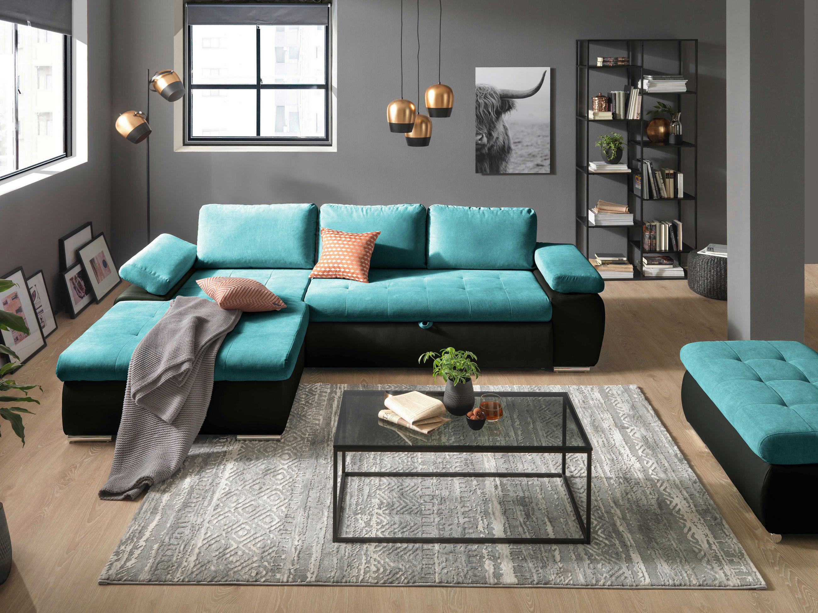MID.YOU ECKSOFA Schwarz, Türkis Flachgewebe, links davon: Decke, rechts davon: Hochflorteppich in grau, Couchtisch in grau, Regal in hellem Wohnzimmer.