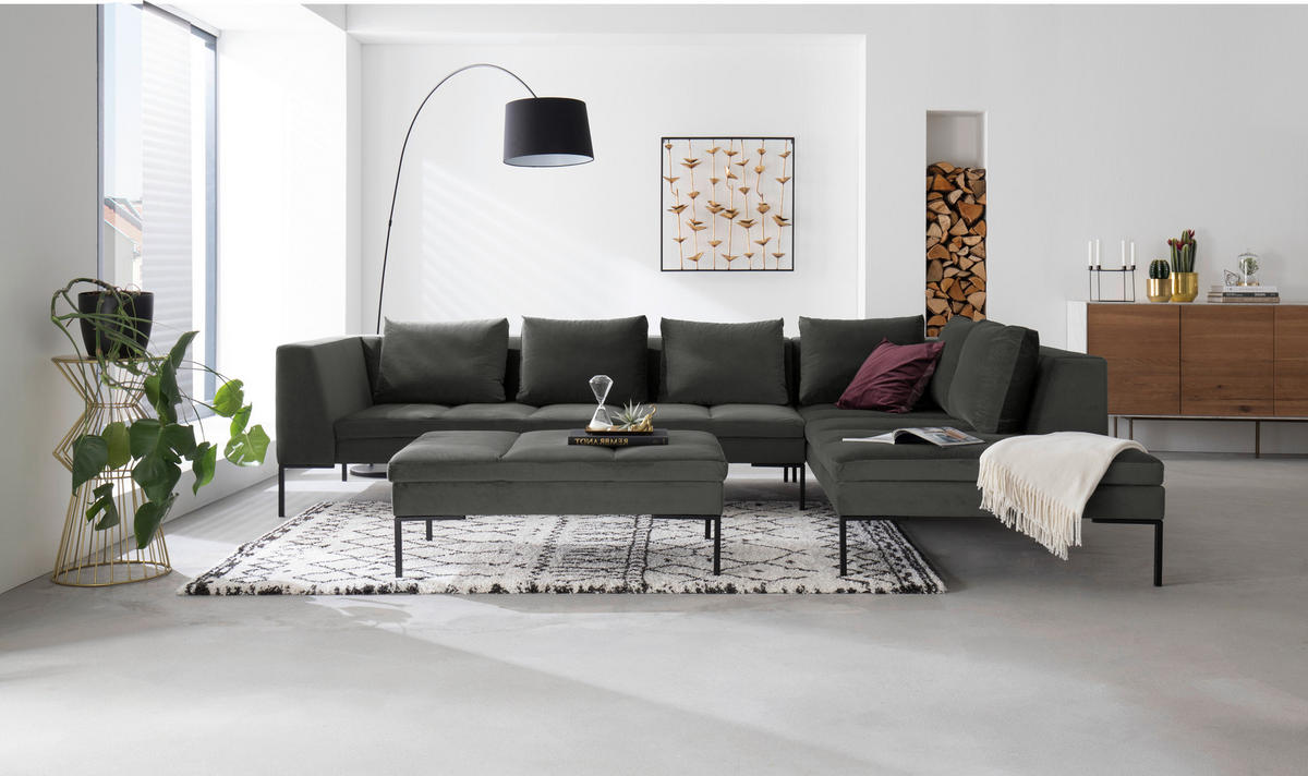 home24 ECKSOFA Grün Velours, links davon: Hochflorteppich in grau, Topfpflanze in grün, rechts davon: Sideboard, Decke in hellem Wohnzimmer.