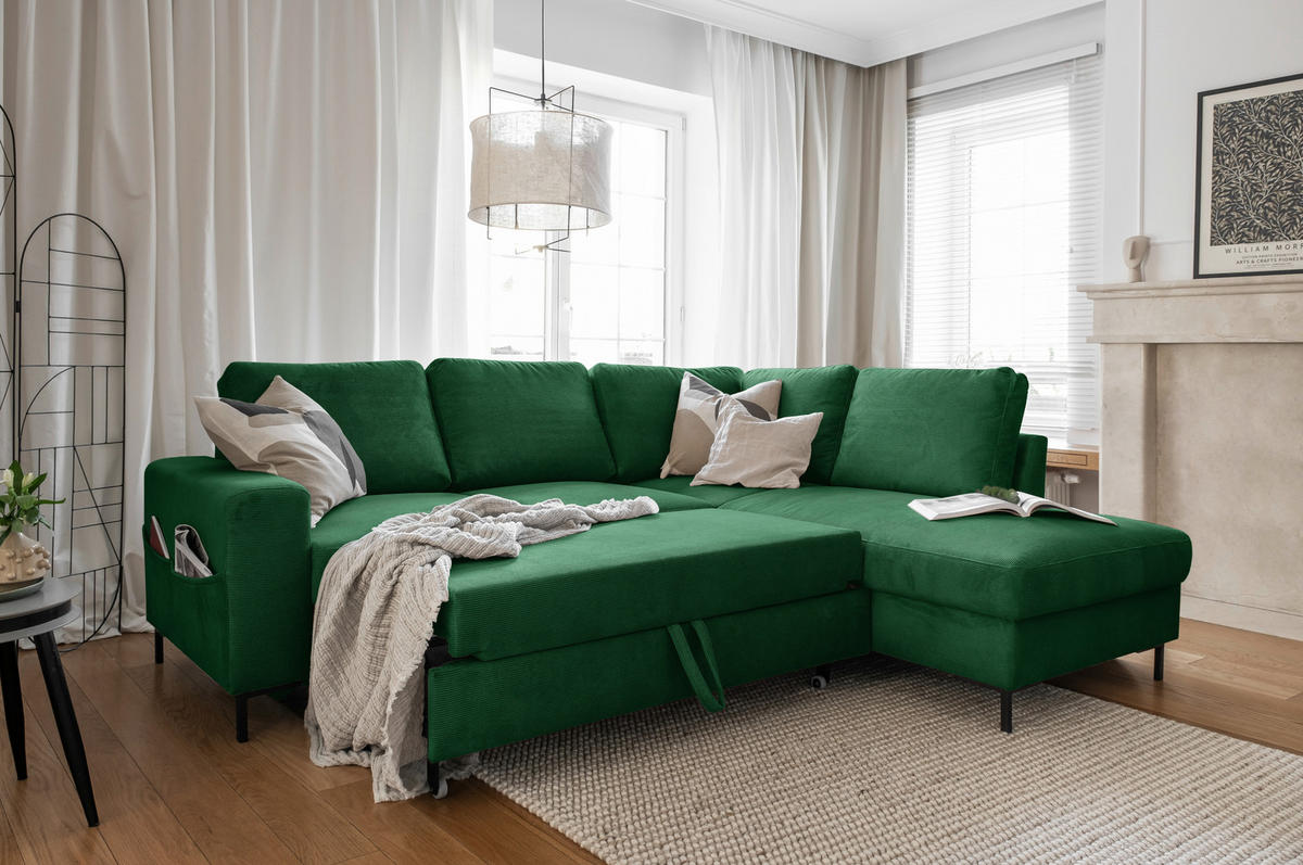 MID.YOU ECKSOFA Smaragdgrün Cord, links davon: Gardine in grün, Decke in grün, rechts davon: Webteppich in grün, Konsolentisch in grün in hellem Wohnzimmer.
