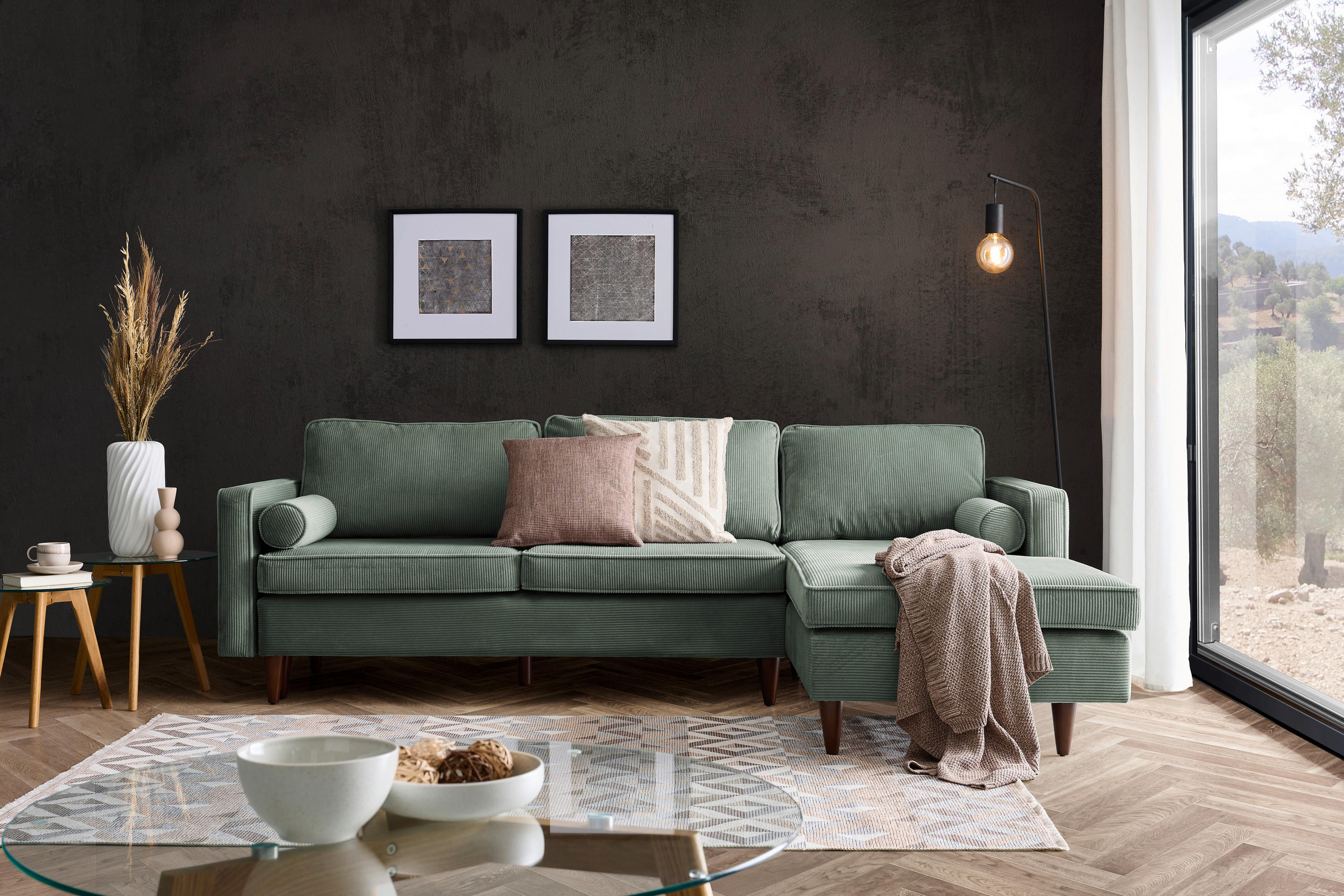 Livetastic ECKSOFA Grün Cord, links davon: Webteppich in weiß, Schale, rechts davon: Decke, Kissen in dunklem Wohnzimmer.