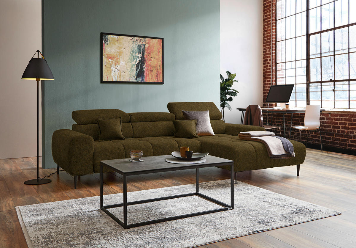 Welnova ECKSOFA Olivgrün Samt, Webstoff, links davon: Hochflorteppich in grau, Bild, rechts davon: Couchtisch, Decke in hellem Wohnzimmer.