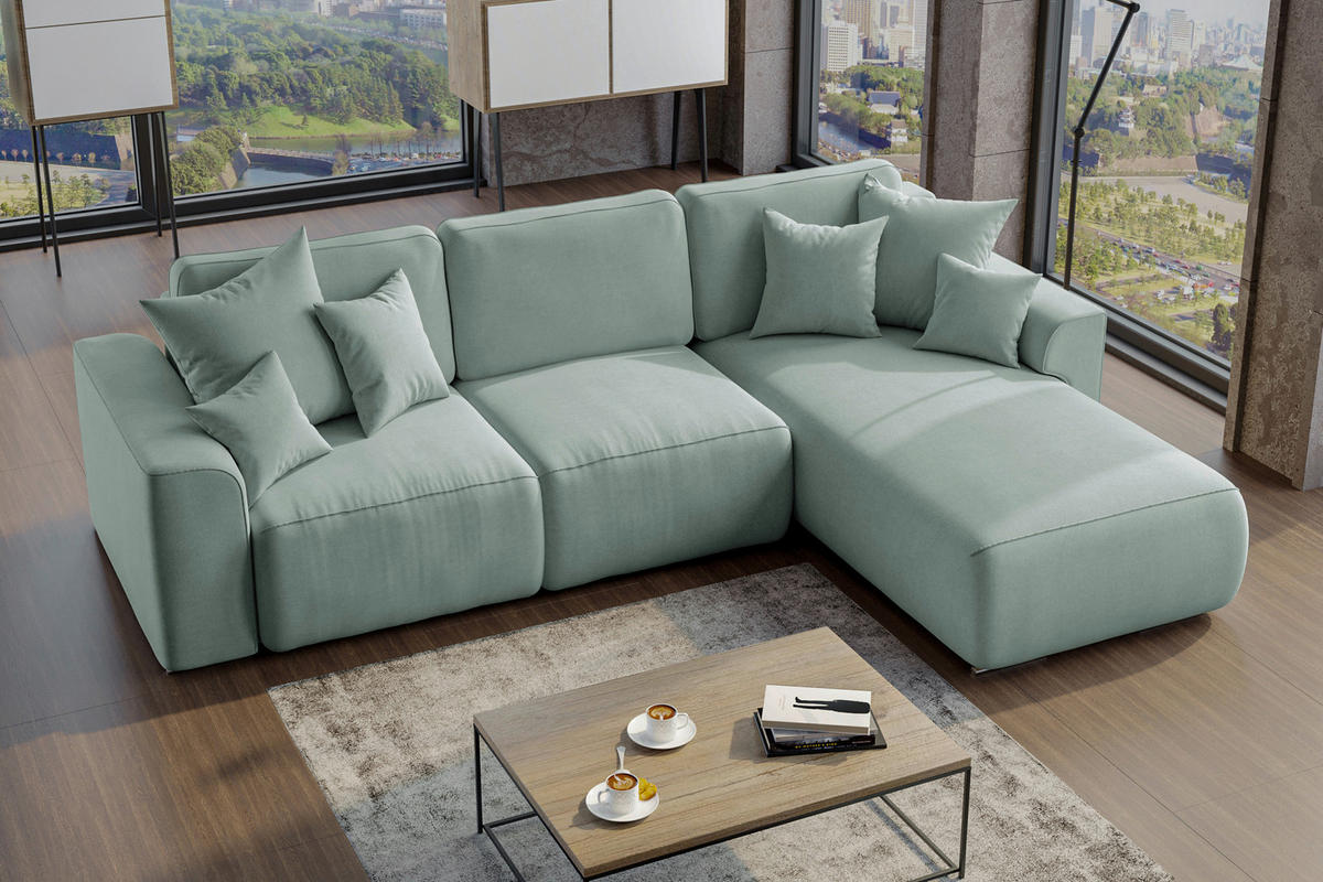 Carryhome ECKSOFA Mintgrün Velours, links davon: Hochflorteppich, Sofa, rechts davon: Couchtisch, Lektüre in schwarz in hellem Wohnzimmer.