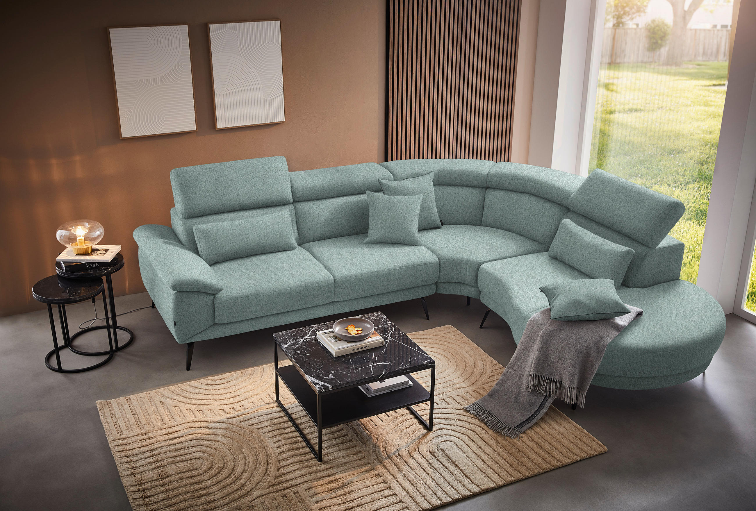 Novel ECKSOFA Mintgrün Velours, links davon: Webteppich, rechts davon: Decke, Couchtisch, Kissen in hellem Wohnzimmer.