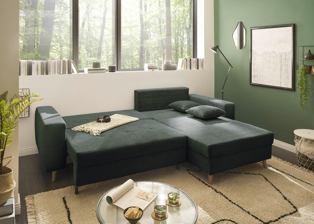 Livetastic ECKSOFA Dunkelgrün Cord, links davon: Webteppich, Lektüre, rechts davon: Beistelltisch in grün, Bild in weiß in hellem Wohnzimmer.