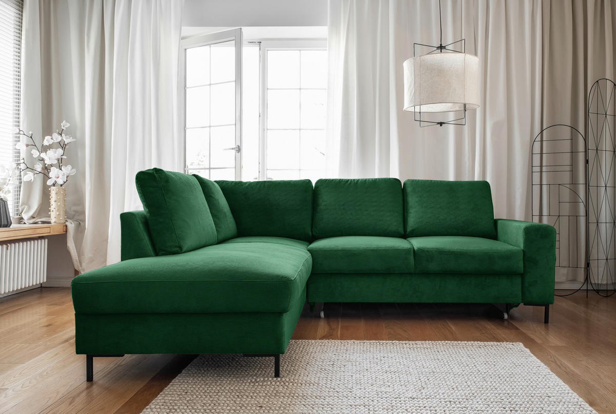 MID.YOU ECKSOFA Smaragdgrün Cord, links davon: Vase, rechts davon: Hochflorteppich in weiß, Gardine in grün in hellem Wohnzimmer.
