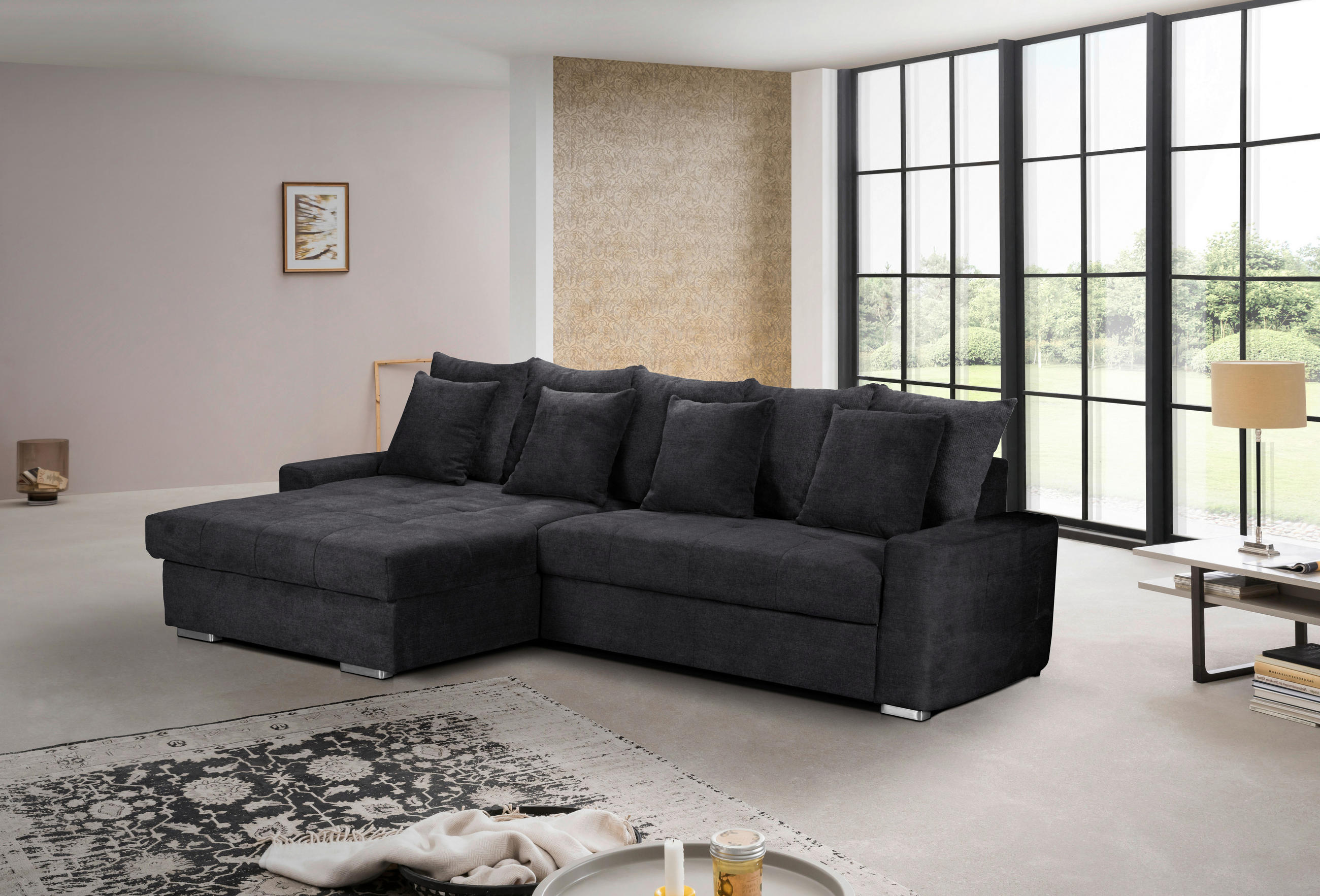 MID.YOU ECKSOFA SALVADOR Schwarz Mikrofaser, links davon: Hochflorteppich in weiß, rechts davon: Beistelltisch in weiß, Lowboard, Kissen in hellem Wohnzimmer.
