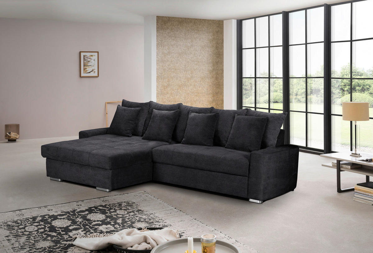 MID.YOU ECKSOFA SALVADOR Schwarz Mikrofaser, links davon: Hochflorteppich in weiß, rechts davon: Beistelltisch in weiß, Lowboard, Kissen in hellem Wohnzimmer.