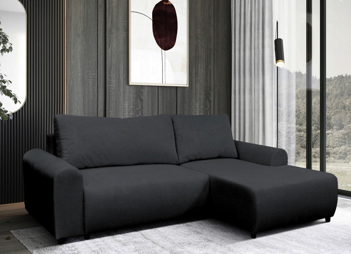 MID.YOU ECKSOFA Schwarz Struktur, rechts davon: Webteppich in schwarz, Gardine, Store in dunklem Wohnzimmer.